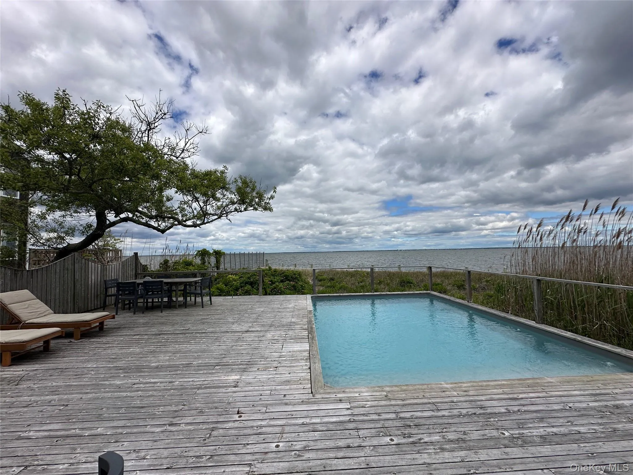 View of swimming pool featuring a wooden deck and outdoor dining area View of swimming pool featuring a wooden deck and outdoor dining area
