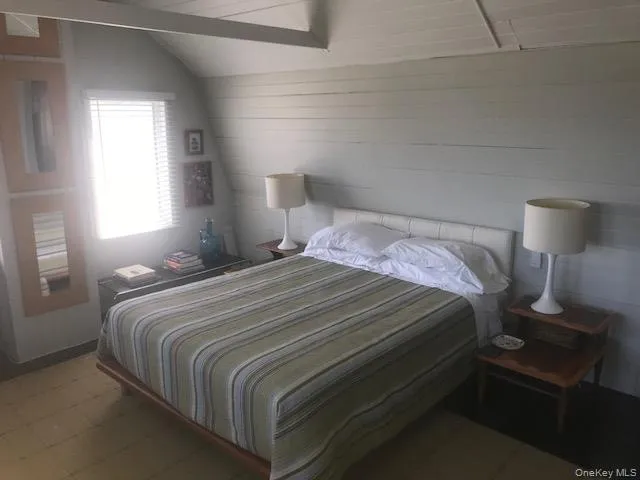 Bedroom with tile patterned floors and lofted ceiling Bedroom with tile patterned floors and lofted ceiling