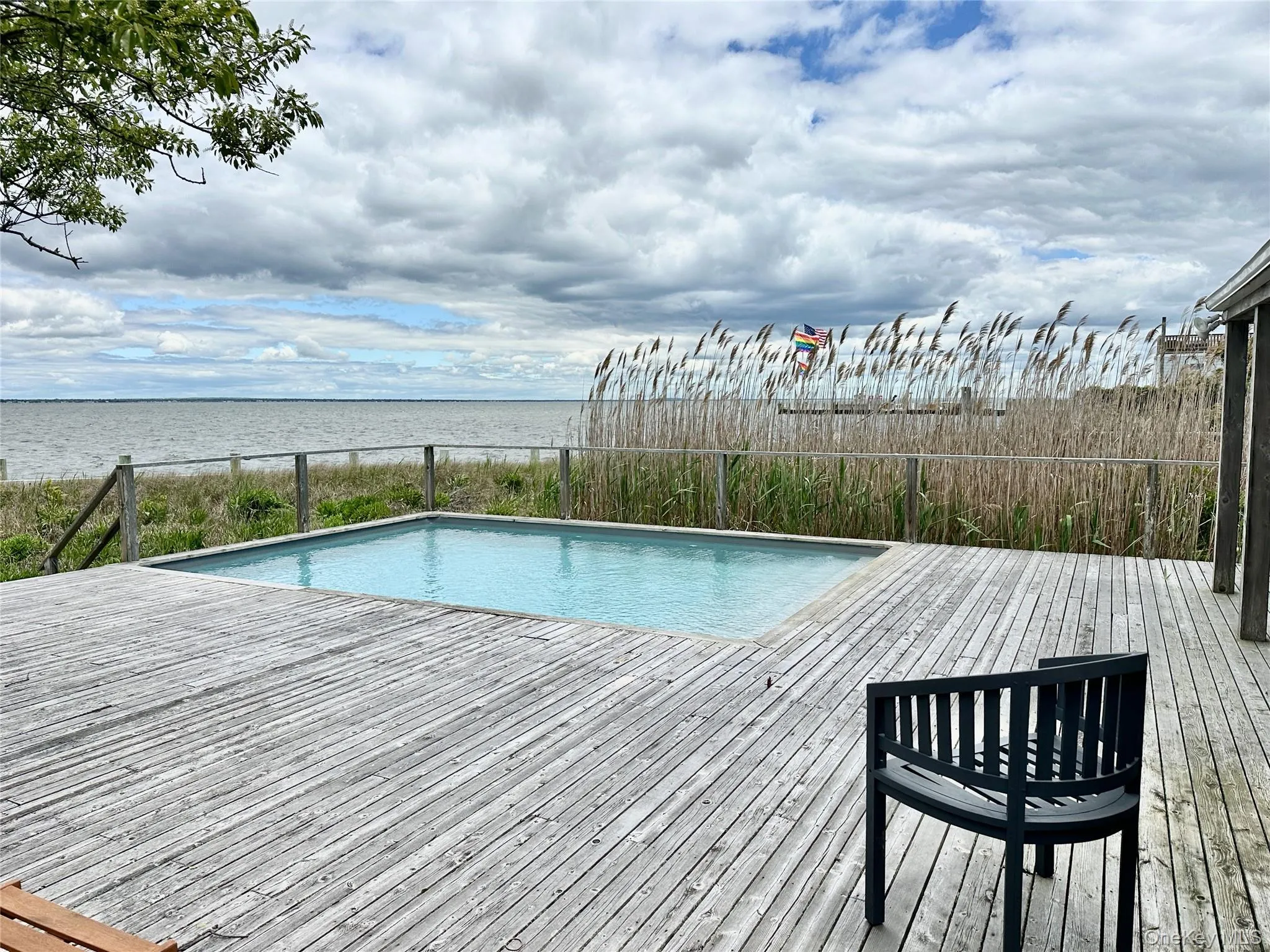 Swimming pool featuring a deck with water view Swimming pool featuring a deck with water view