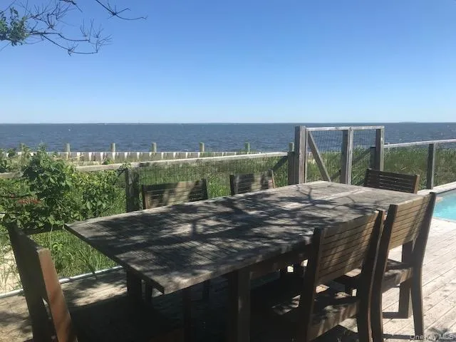 View of patio / terrace featuring outdoor dining space, an outdoor pool, and a deck with water view View of patio / terrace featuring outdoor dining space, an outdoor pool, and a deck with water view