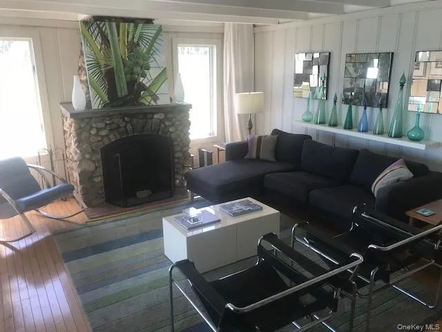 Living room with plenty of natural light, hardwood / wood-style floors, a decorative wall, and a fireplace Living room with plenty of natural light, hardwood / wood-style floors, a decorative wall, and a fireplace