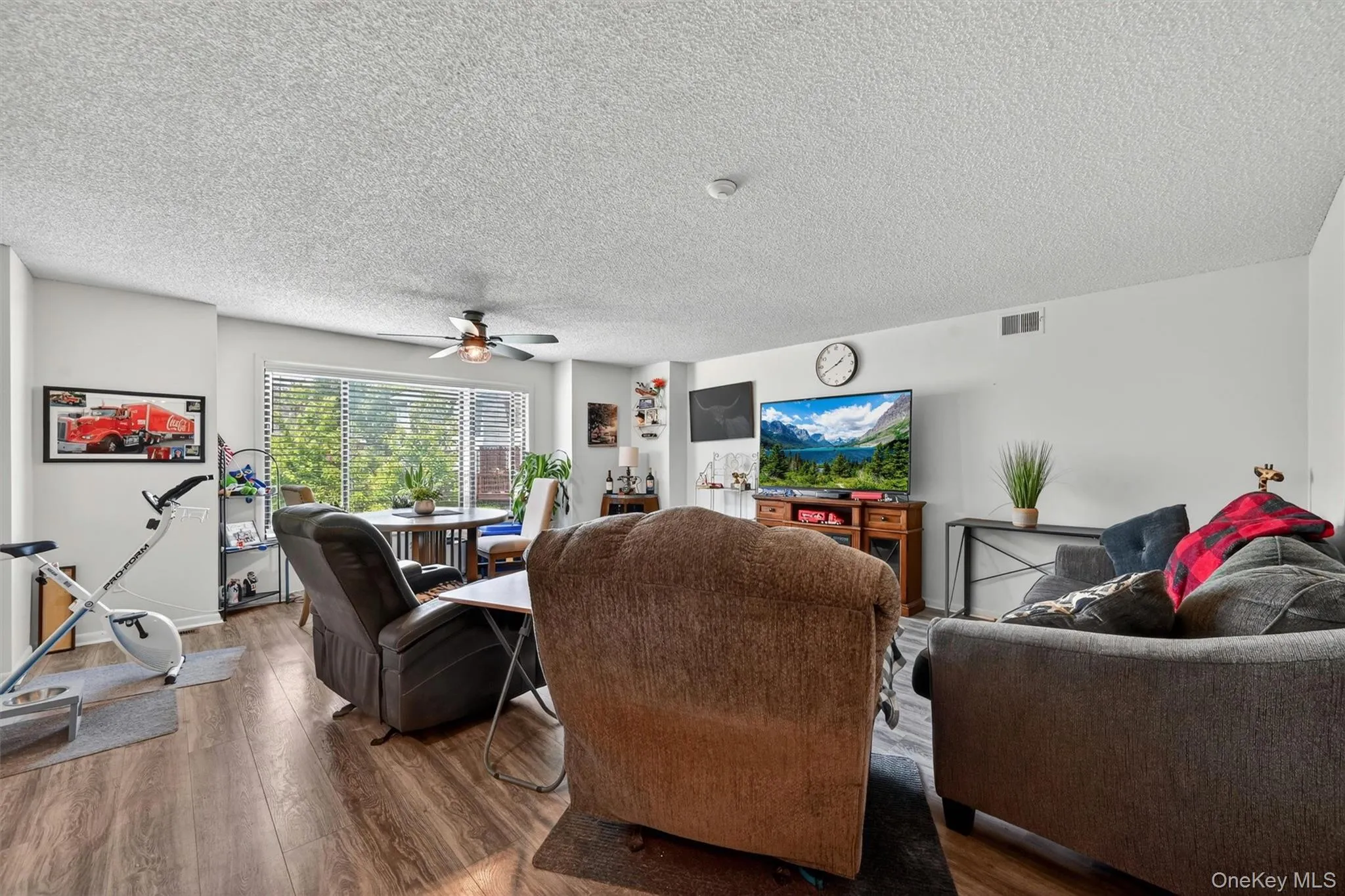 Large open concept living room and dining room with oversized window overlooking the courtyard. Large open concept living room and dining room with oversized window overlooking the courtyard.