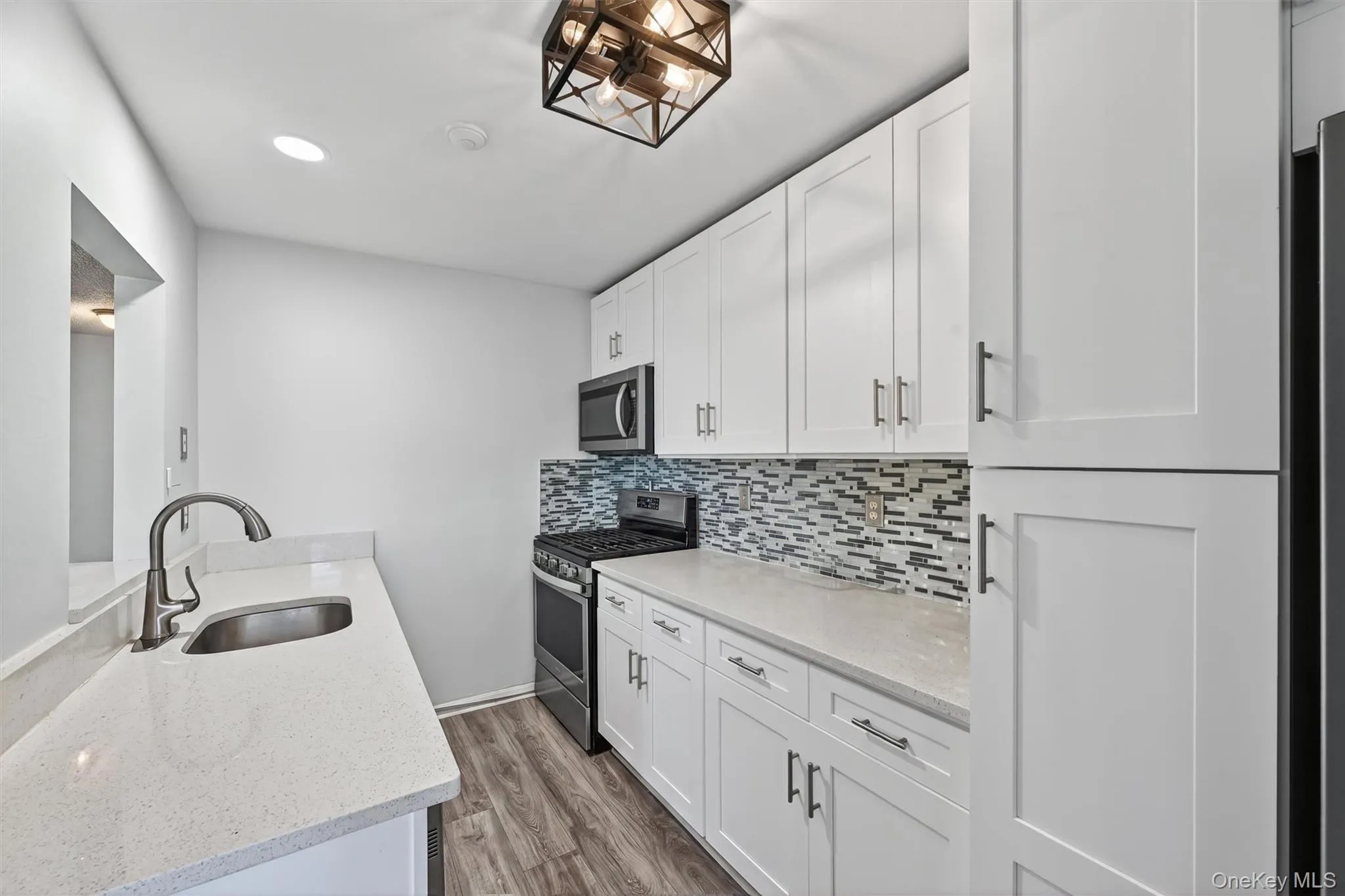 Custom kitchen with tile backsplash, stainless steel appliances and white cabinets. Custom kitchen with tile backsplash, stainless steel appliances and white cabinets.