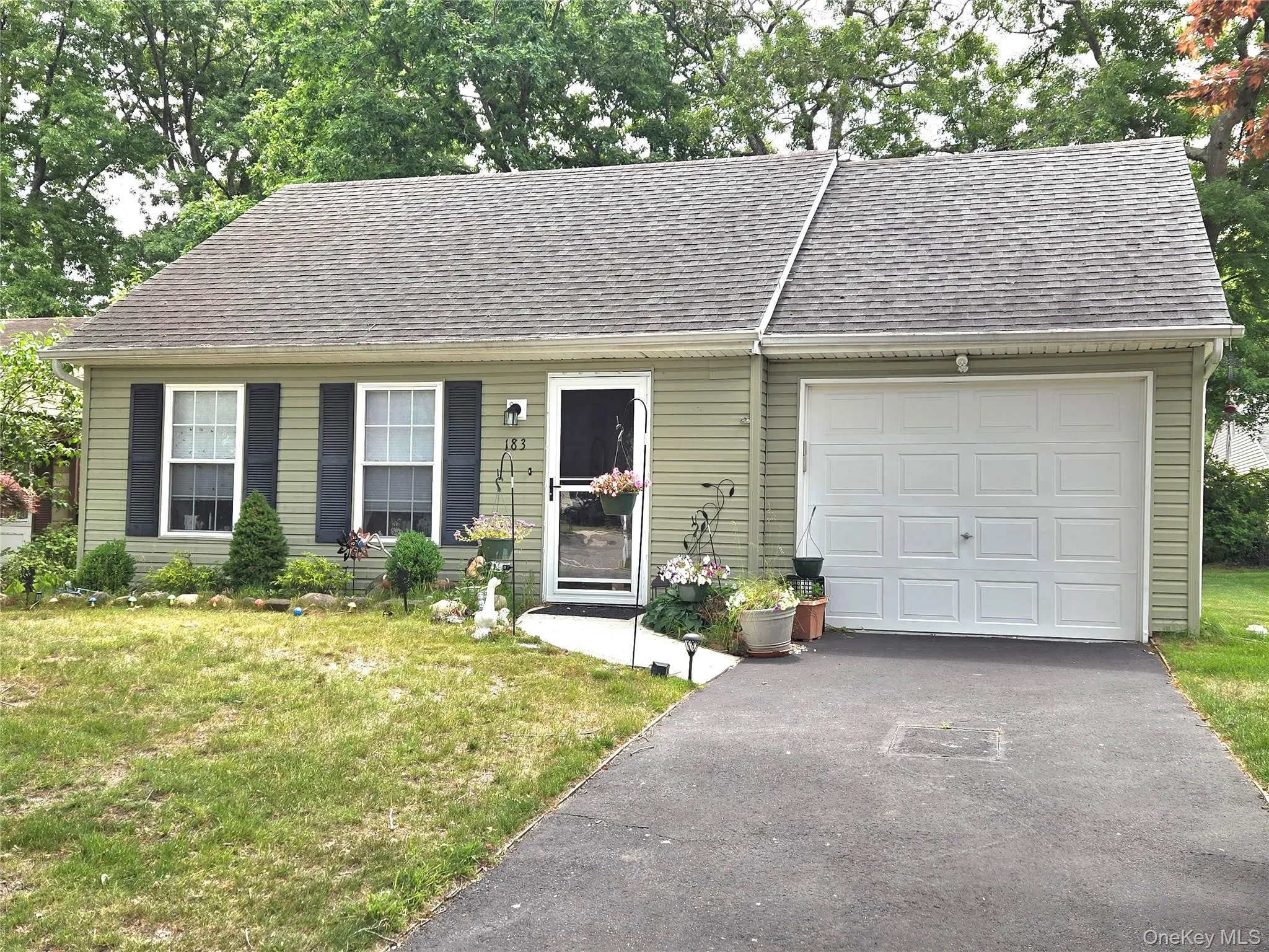 Ranch-style residence featuring light green vinyl siding and an asphalt shingle roof Ranch-style residence featuring light green vinyl siding and an asphalt shingle roof