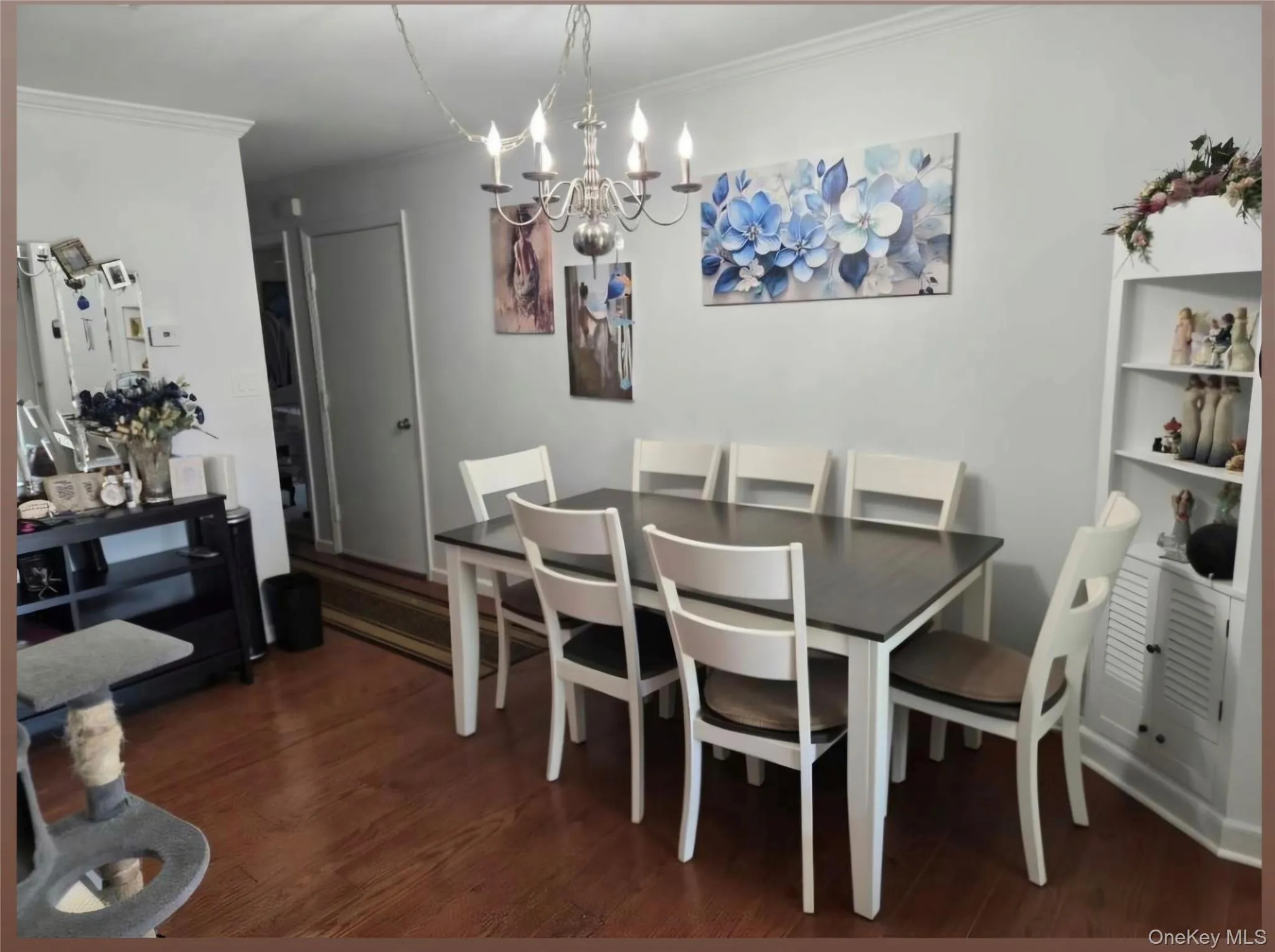Dining area featuring laminate flooring, a contemporary chandelier. Digitally removed personal items Dining area featuring laminate flooring, a contemporary chandelier. Digitally removed personal items