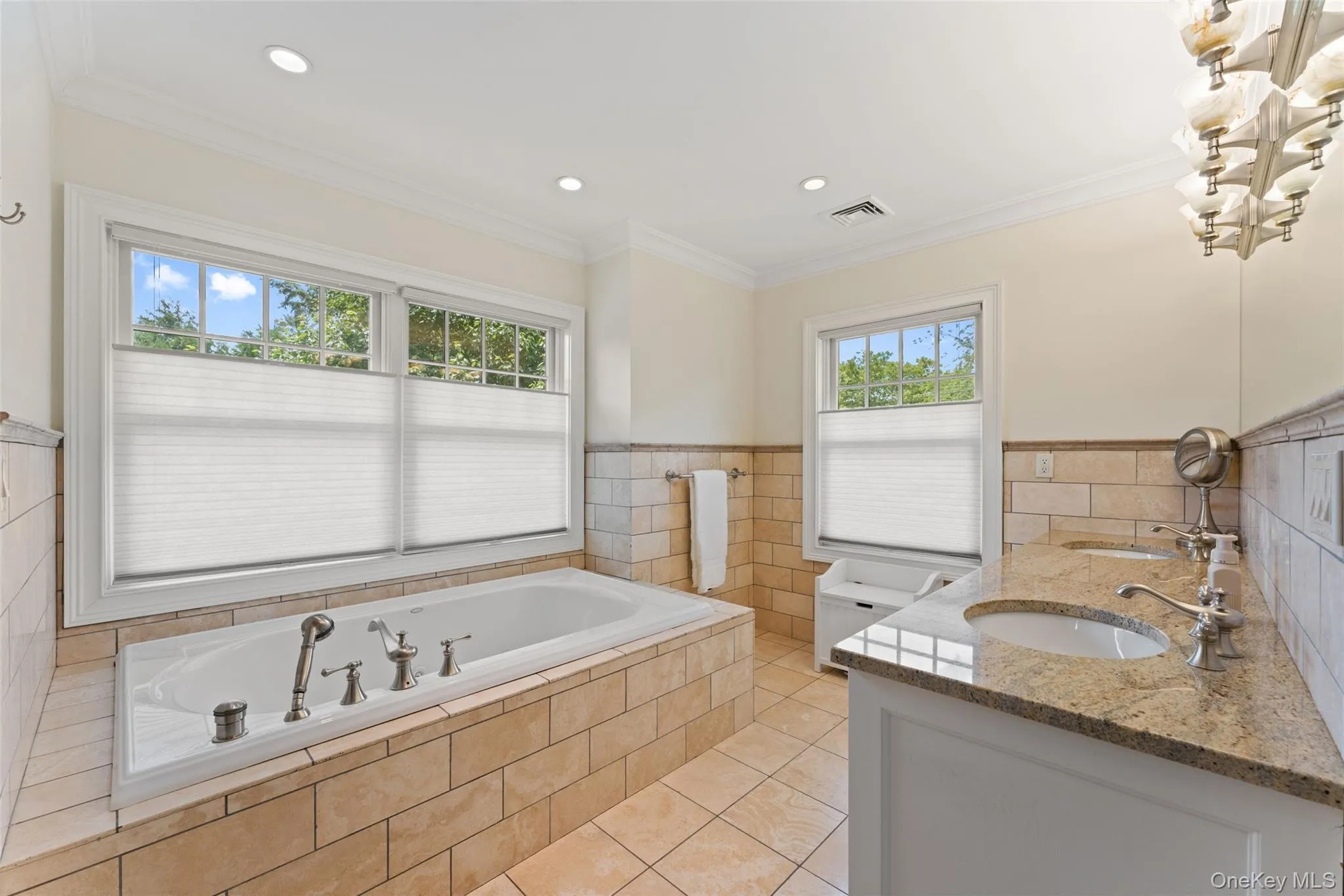 Primary Bathroom featuring a dual vanity with white cabinetry and stone countertops, a glass-enclosed shower, a built-in jetted tub, recessed lighting, and tile flooring Primary Bathroom featuring a dual vanity with white cabinetry and stone countertops, a glass-enclosed shower, a built-in jetted tub, recessed lighting, and tile flooring