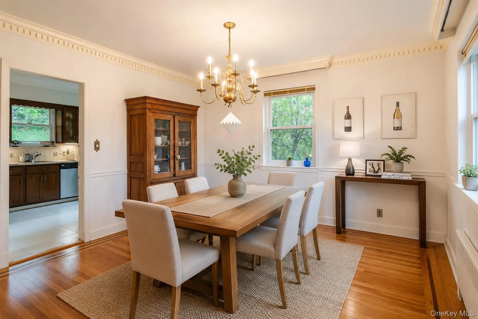 Formal dining space featuring hardwood flooring, wainscoting, and crown molding Formal dining space featuring hardwood flooring, wainscoting, and crown molding