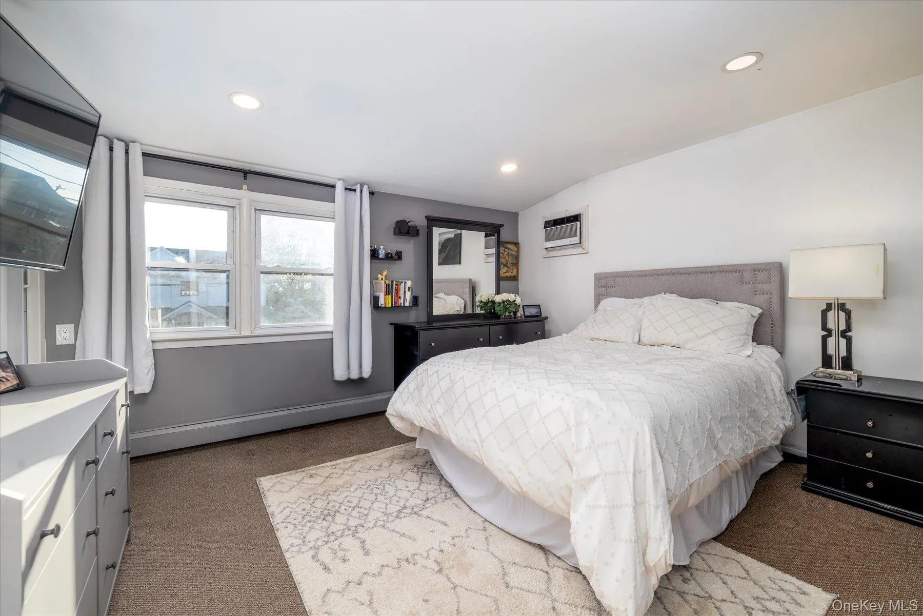 Spacious primary bedroom featuring hardwood flooring and recessed lighting Spacious primary bedroom featuring hardwood flooring and recessed lighting
