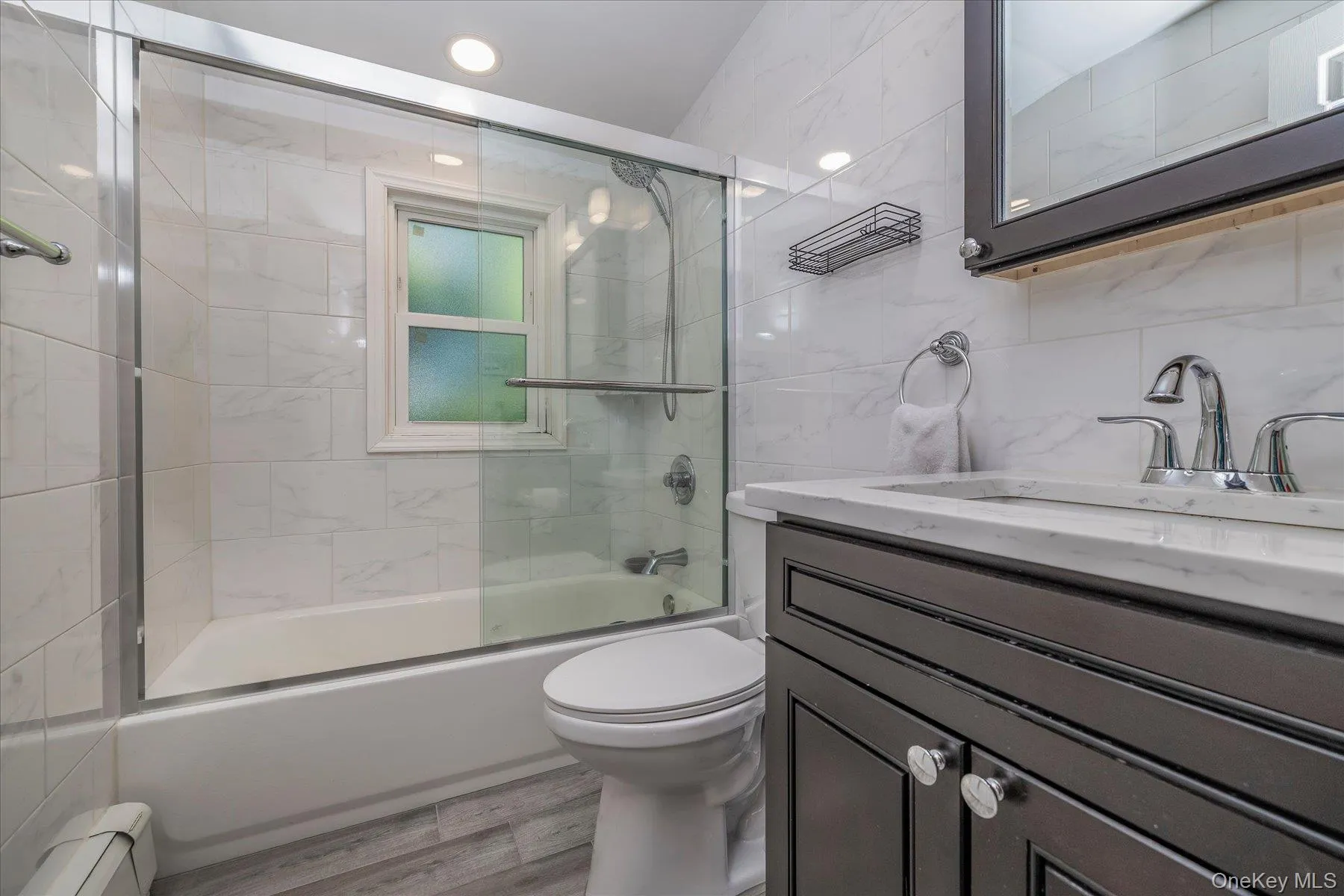 Bathroom featuring a tub and shower combination with glass doors Bathroom featuring a tub and shower combination with glass doors
