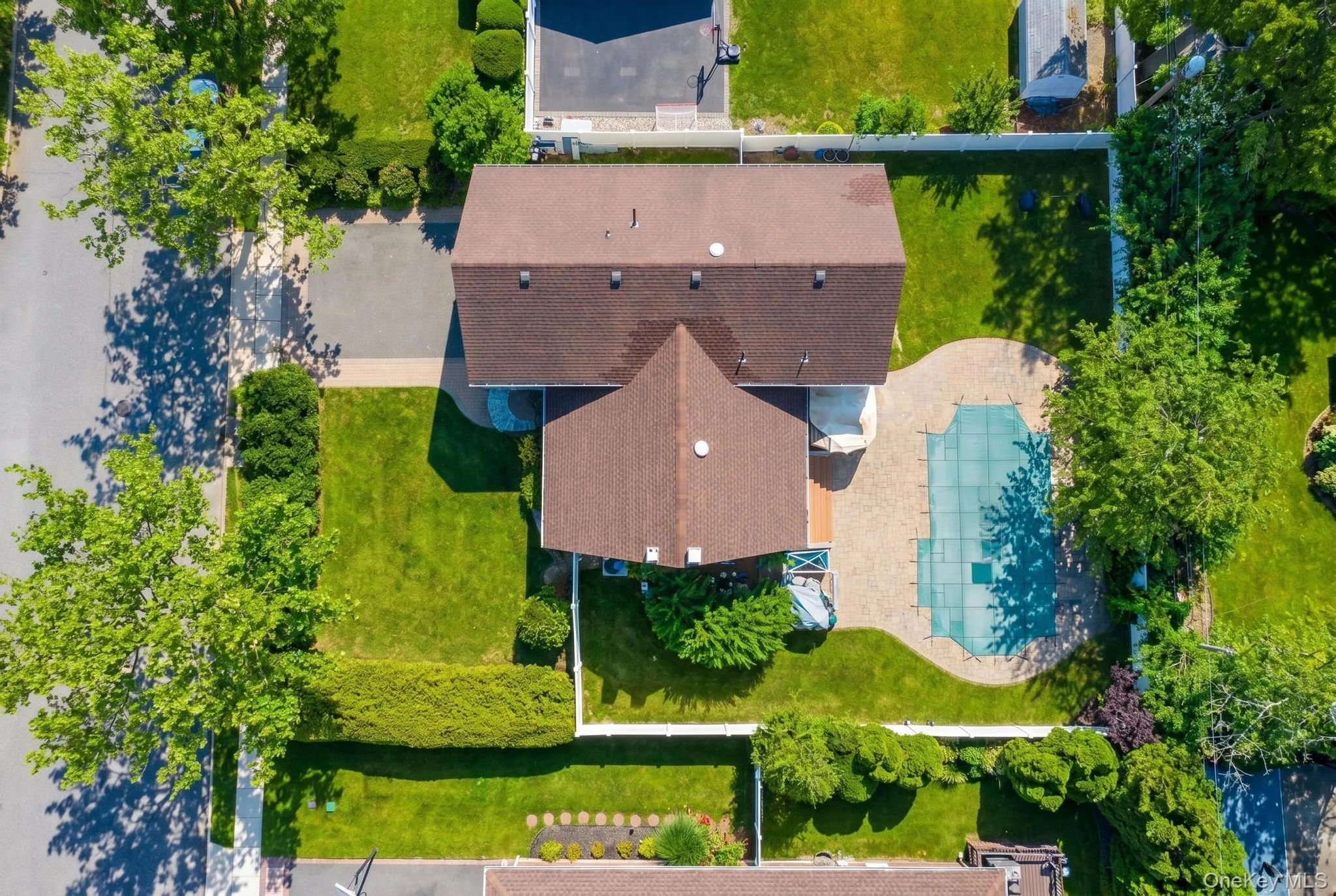 Expansive outdoor area featuring a covered pool, a paved patio surround, and a large grassy yard Expansive outdoor area featuring a covered pool, a paved patio surround, and a large grassy yard