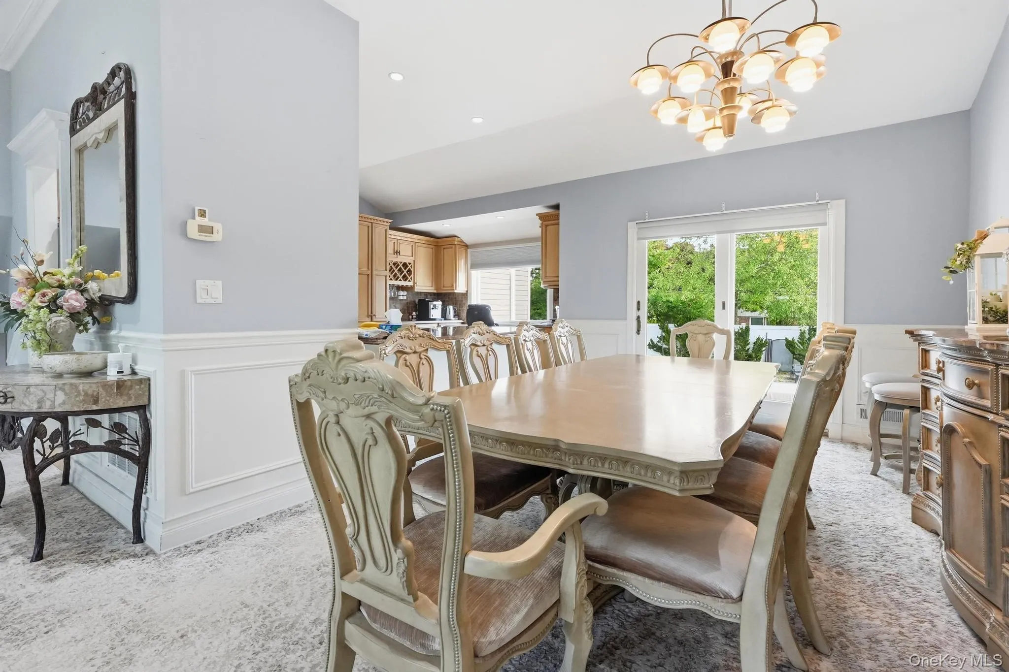 Dining area featuring a decorative chandelier, wainscoting, and large sliding glass doors providing access to outdoor space Dining area featuring a decorative chandelier, wainscoting, and large sliding glass doors providing access to outdoor space