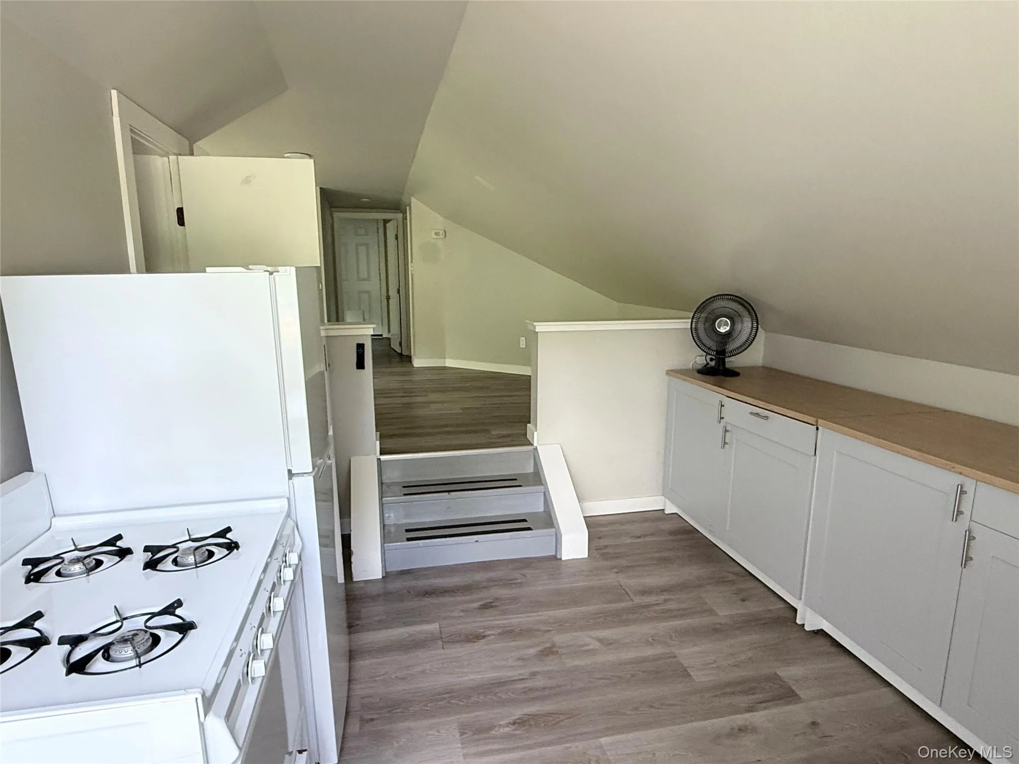 space featuring wood-finish flooring, white walls, and a multi-level layout space featuring wood-finish flooring, white walls, and a multi-level layout