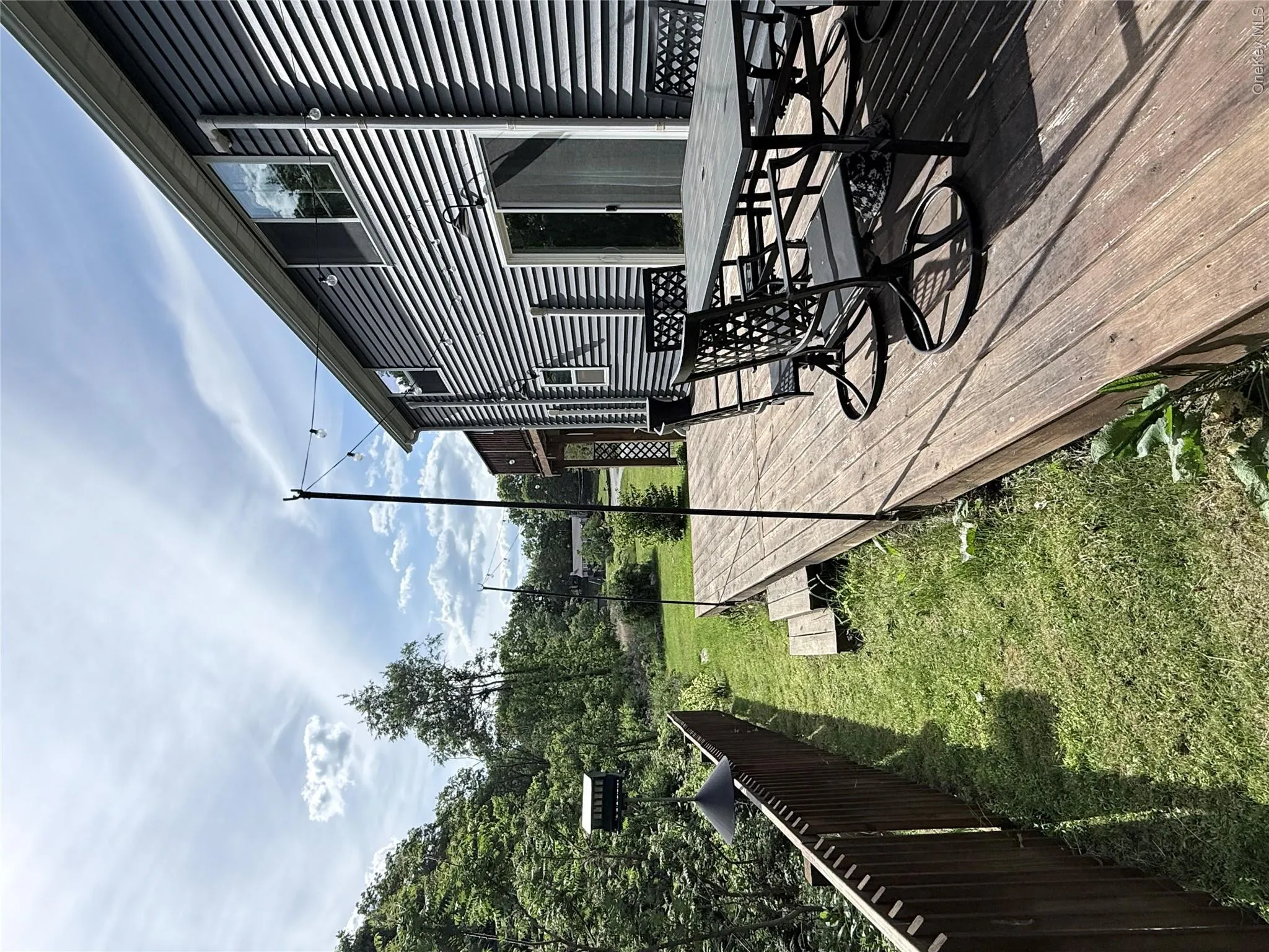 Spacious wood-finish deck with multiple levels, offering outdoor living space Spacious wood-finish deck with multiple levels, offering outdoor living space