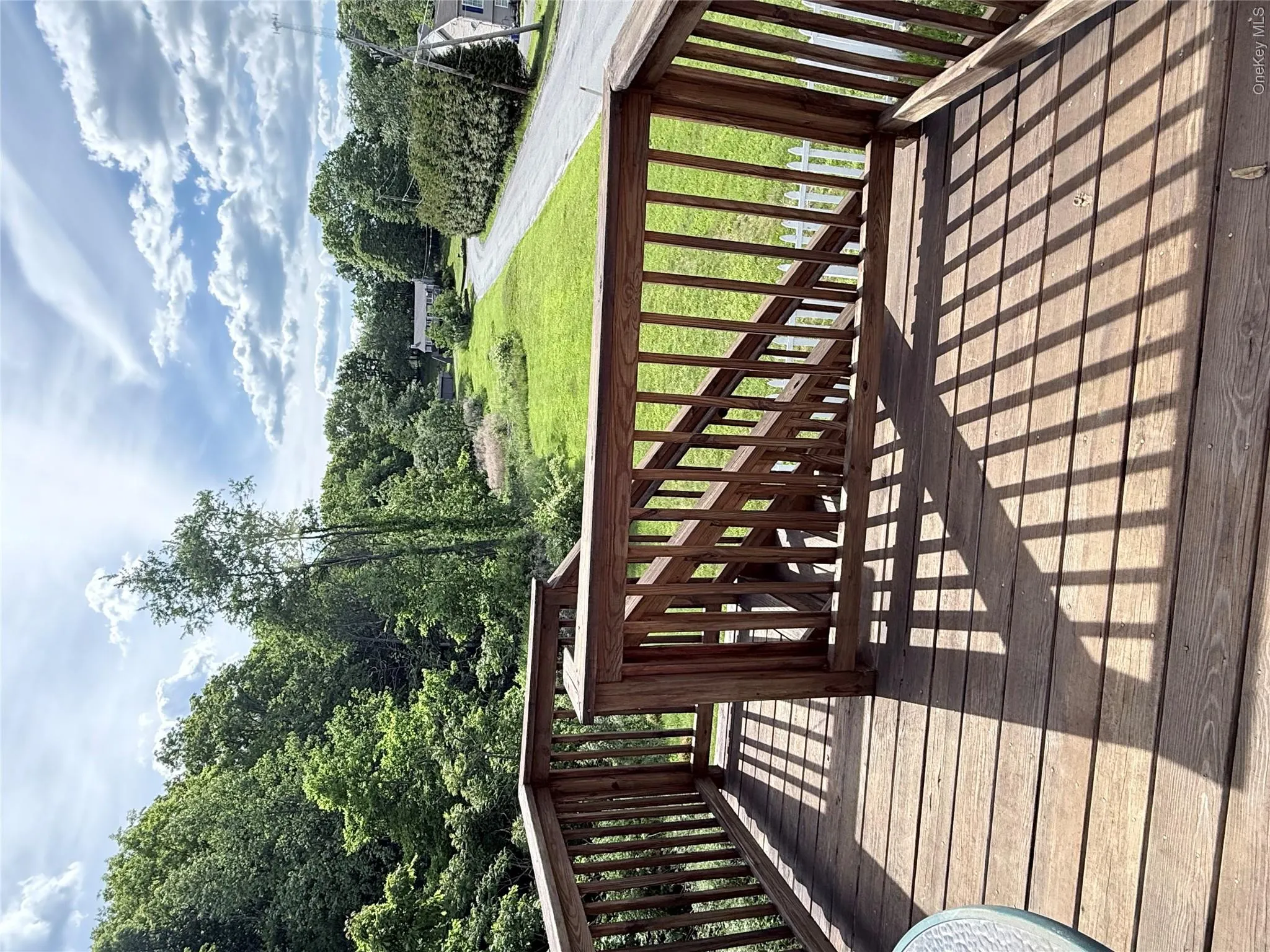 Spacious wood-finish deck with integrated wood railings and staircase Spacious wood-finish deck with integrated wood railings and staircase