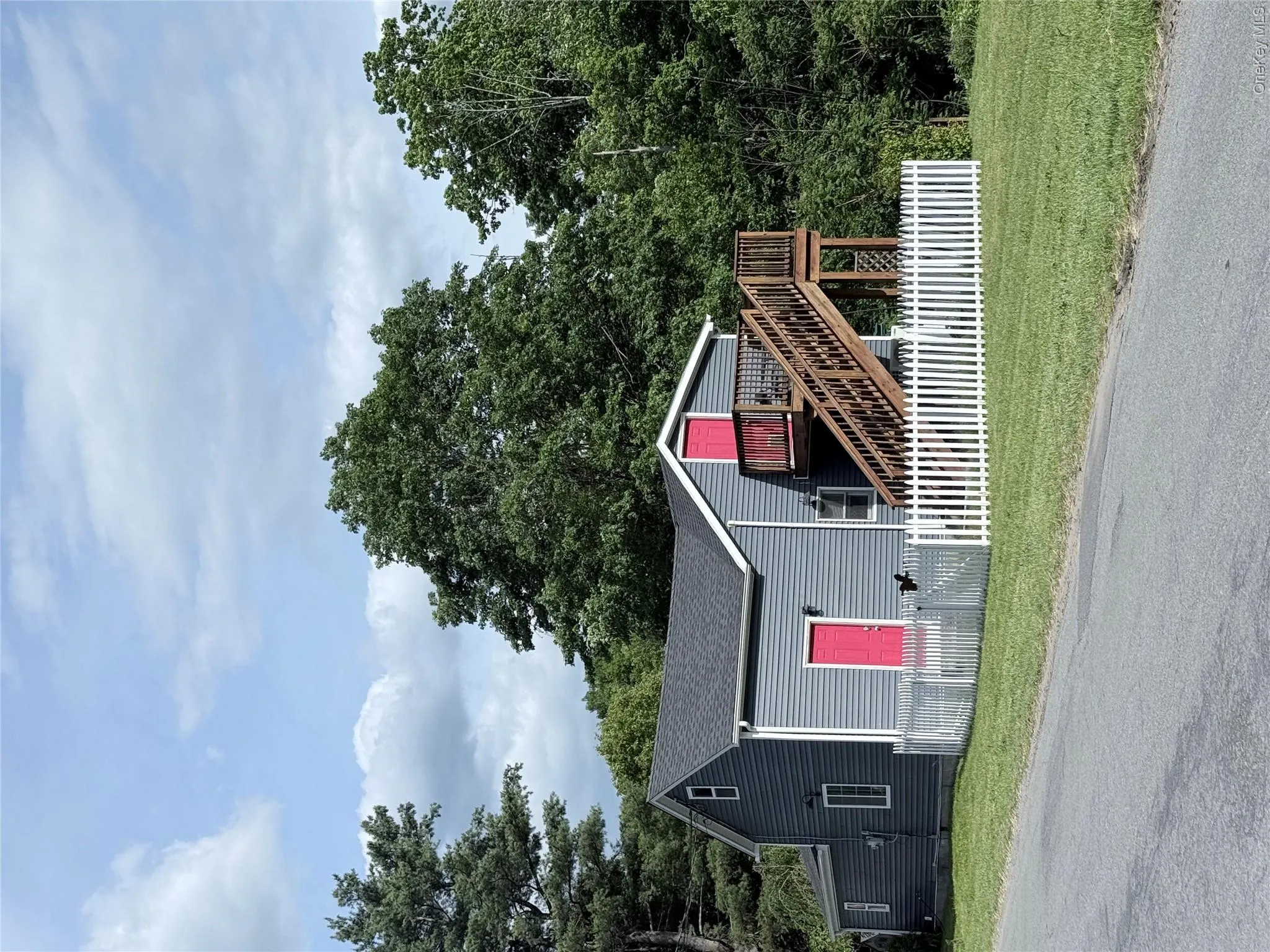 Two-story property featuring gray siding and a dark shingle roof Two-story property featuring gray siding and a dark shingle roof