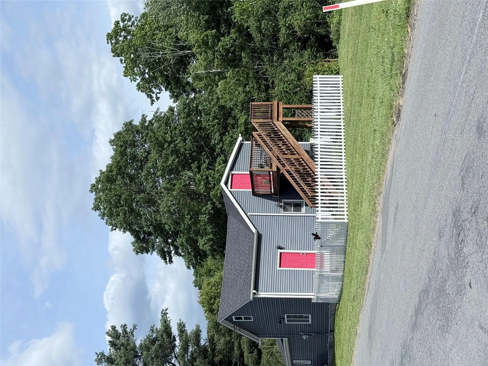 Two-story property featuring gray siding and a dark shingle roof Two-story property featuring gray siding and a dark shingle roof