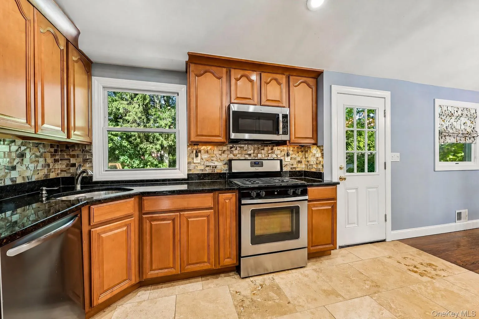 Stainless steel appliances, granite counters, glass tiled backsplash Stainless steel appliances, granite counters, glass tiled backsplash