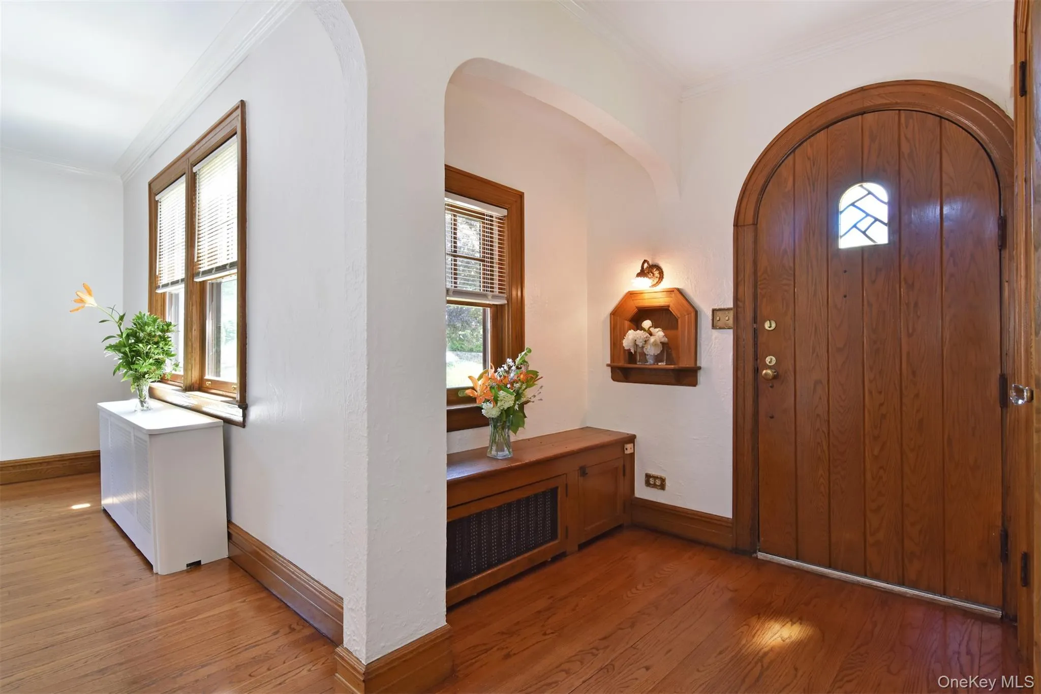 Charming foyer with arched alcove, inset, and entry door with stained glass Charming foyer with arched alcove, inset, and entry door with stained glass