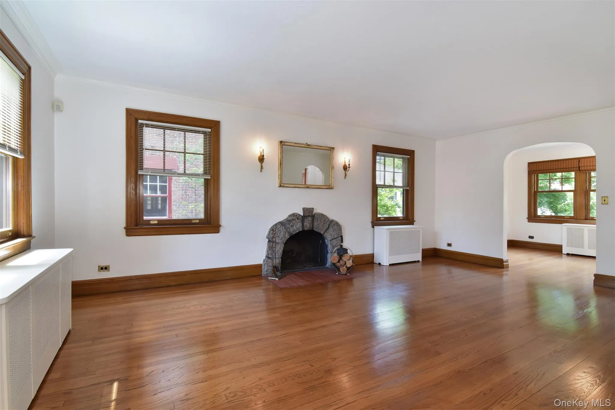 Beautiful living room with exquisite woodwork, stone fireplace and archway to sunroom Beautiful living room with exquisite woodwork, stone fireplace and archway to sunroom