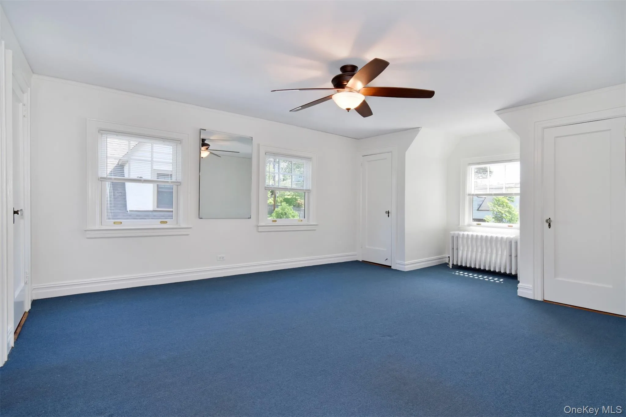 Spacious and bright primary bedroom with arched alcove and three closets Spacious and bright primary bedroom with arched alcove and three closets