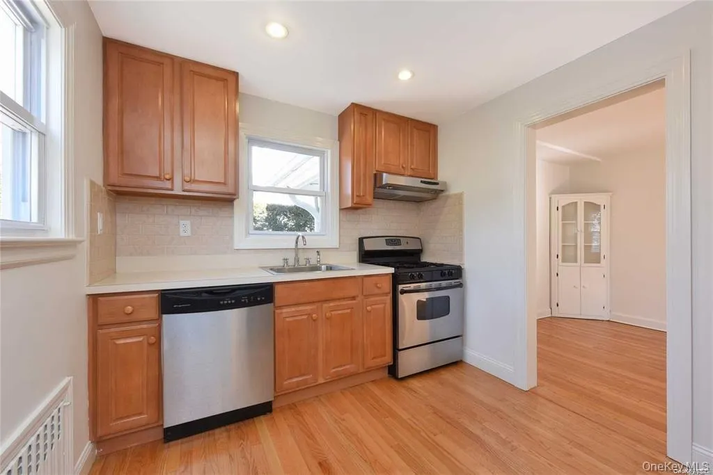 Kitchen featuring appliances with stainless steel finishes, light wood finished floors, backsplash, light countertops, and recessed lighting Kitchen featuring appliances with stainless steel finishes, light wood finished floors, backsplash, light countertops, and recessed lighting