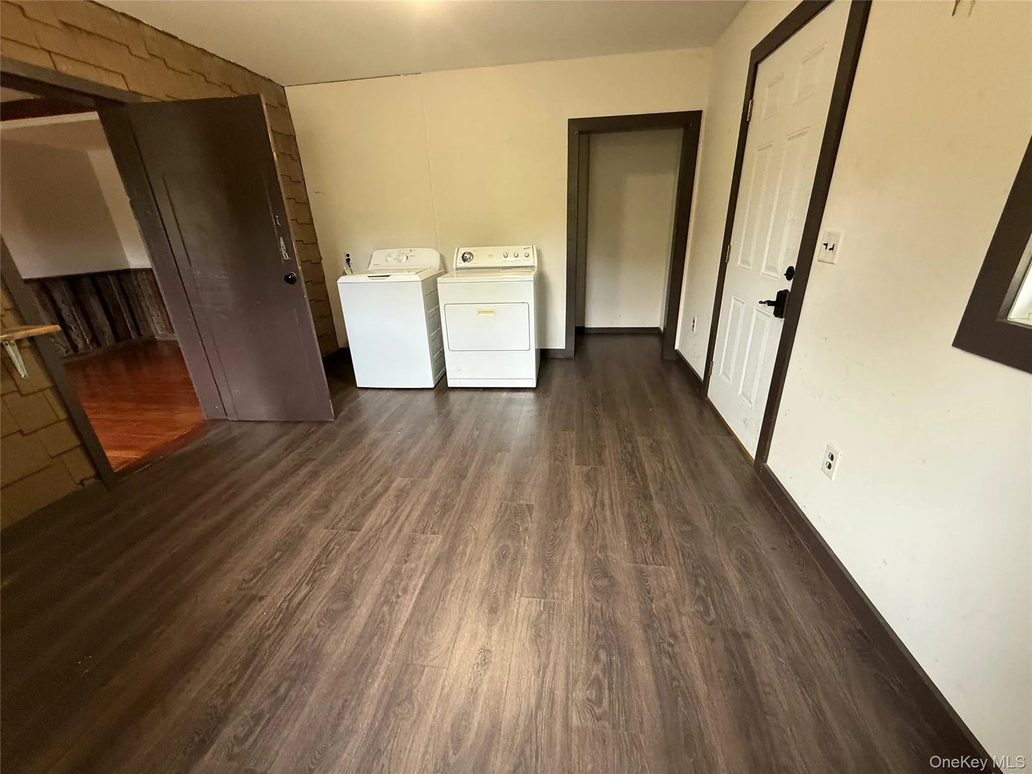 Washroom with dark wood-type flooring and washing machine and dryer Washroom with dark wood-type flooring and washing machine and dryer