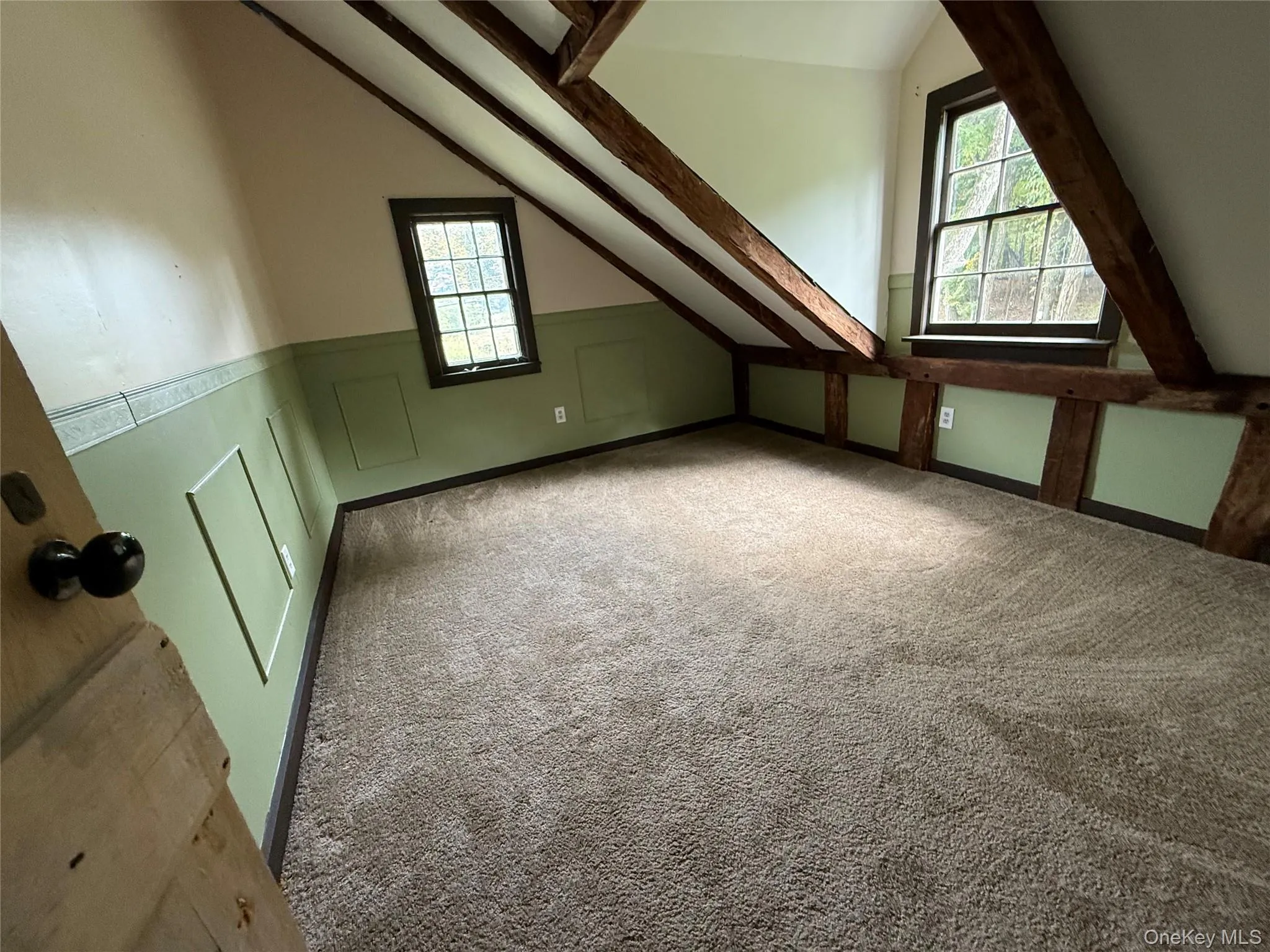 Additional living space with carpet floors, healthy amount of natural light, and a decorative wall Additional living space with carpet floors, healthy amount of natural light, and a decorative wall