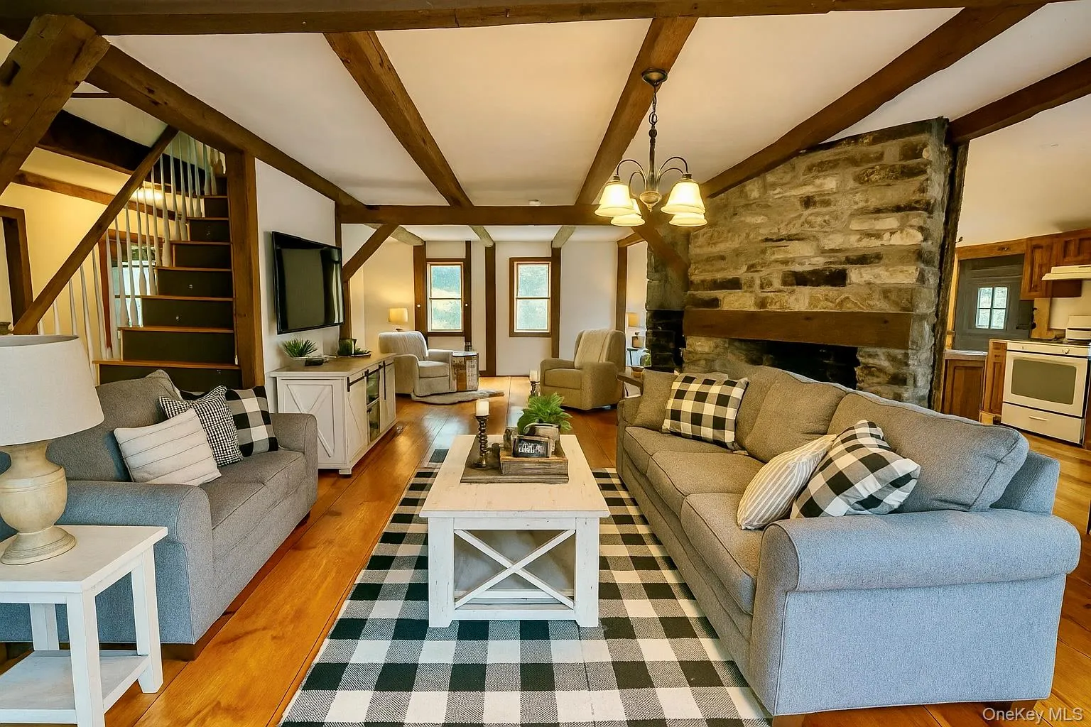 AI Generated Living room with light wood finished floors, a fireplace, beamed ceiling, stairs, and a chandelier AI Generated Living room with light wood finished floors, a fireplace, beamed ceiling, stairs, and a chandelier