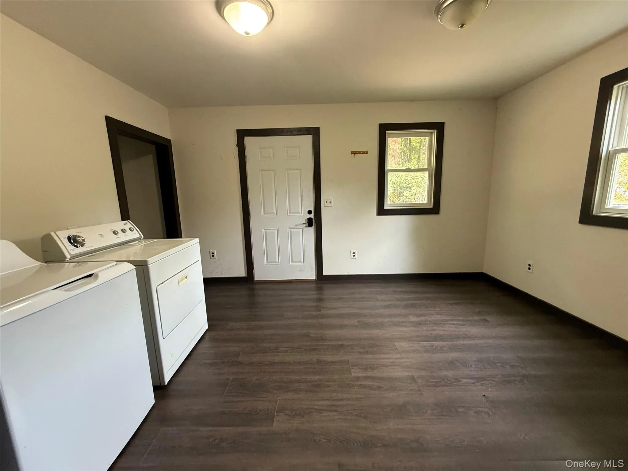 Laundry area with dark wood finished floors and washer and dryer Laundry area with dark wood finished floors and washer and dryer