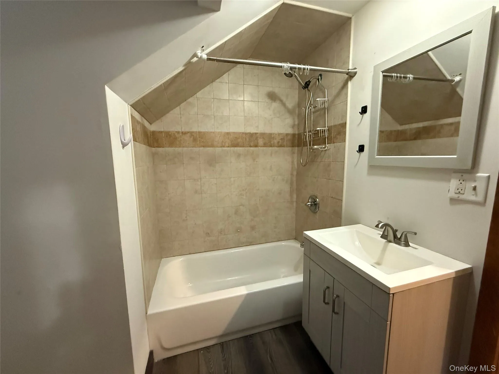 Bathroom with shower / bath combination, vanity, and dark wood finished floors Bathroom with shower / bath combination, vanity, and dark wood finished floors