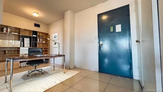 Office area with light tile patterned floors and baseboards Office area with light tile patterned floors and baseboards
