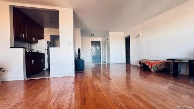 Unfurnished living room featuring light wood-style flooring and baseboards Unfurnished living room featuring light wood-style flooring and baseboards