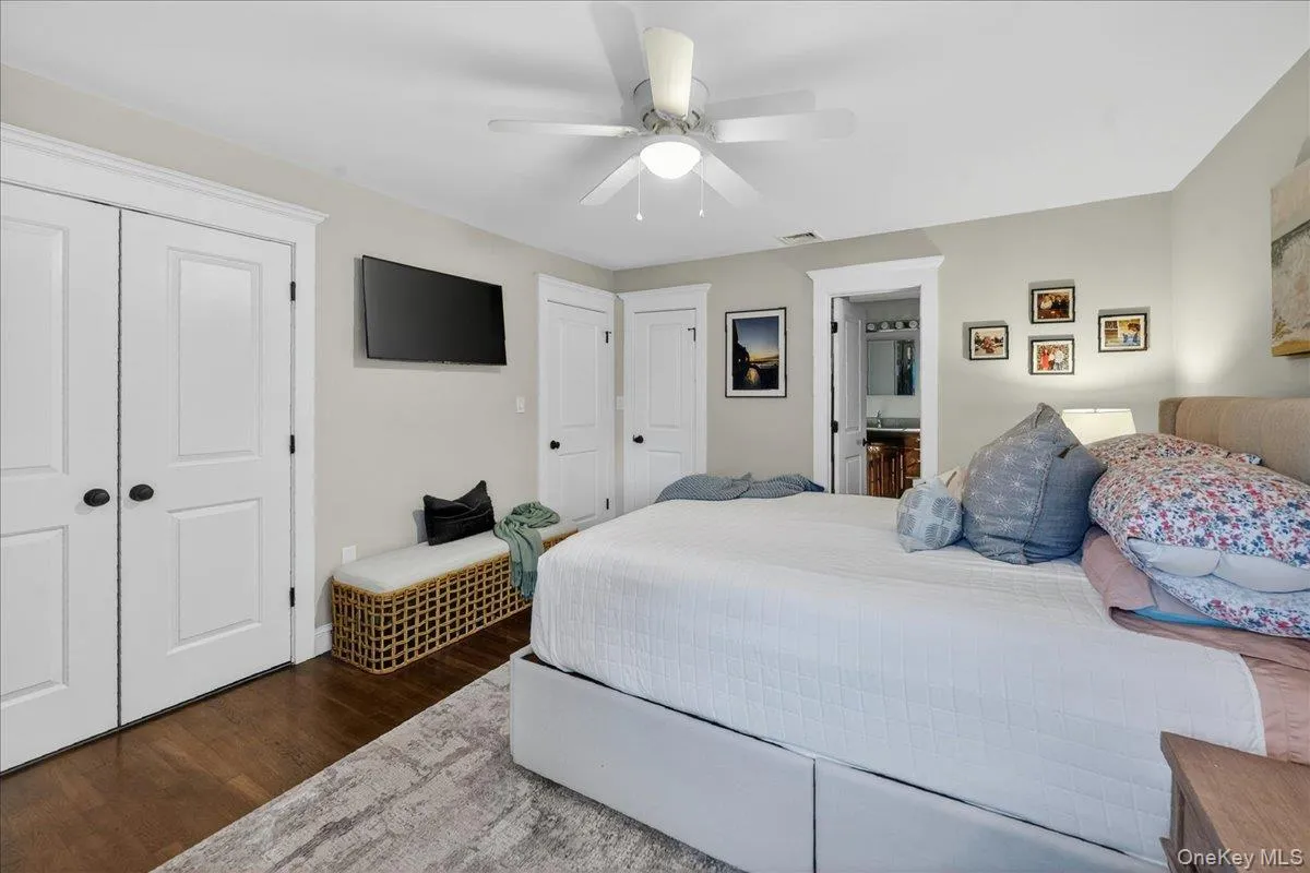 Bedroom featuring wood-finish flooring, a ceiling fan, and a neutral wall color Bedroom featuring wood-finish flooring, a ceiling fan, and a neutral wall color