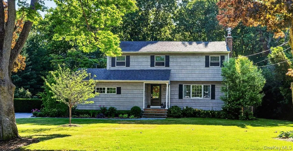 Two-story residence featuring grey shingle siding and dark shutters Two-story residence featuring grey shingle siding and dark shutters