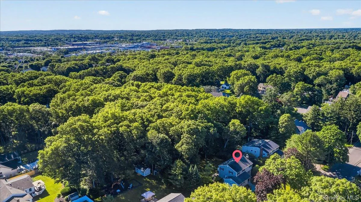 Aerial view showcasing a residential property surrounded by mature trees Aerial view showcasing a residential property surrounded by mature trees