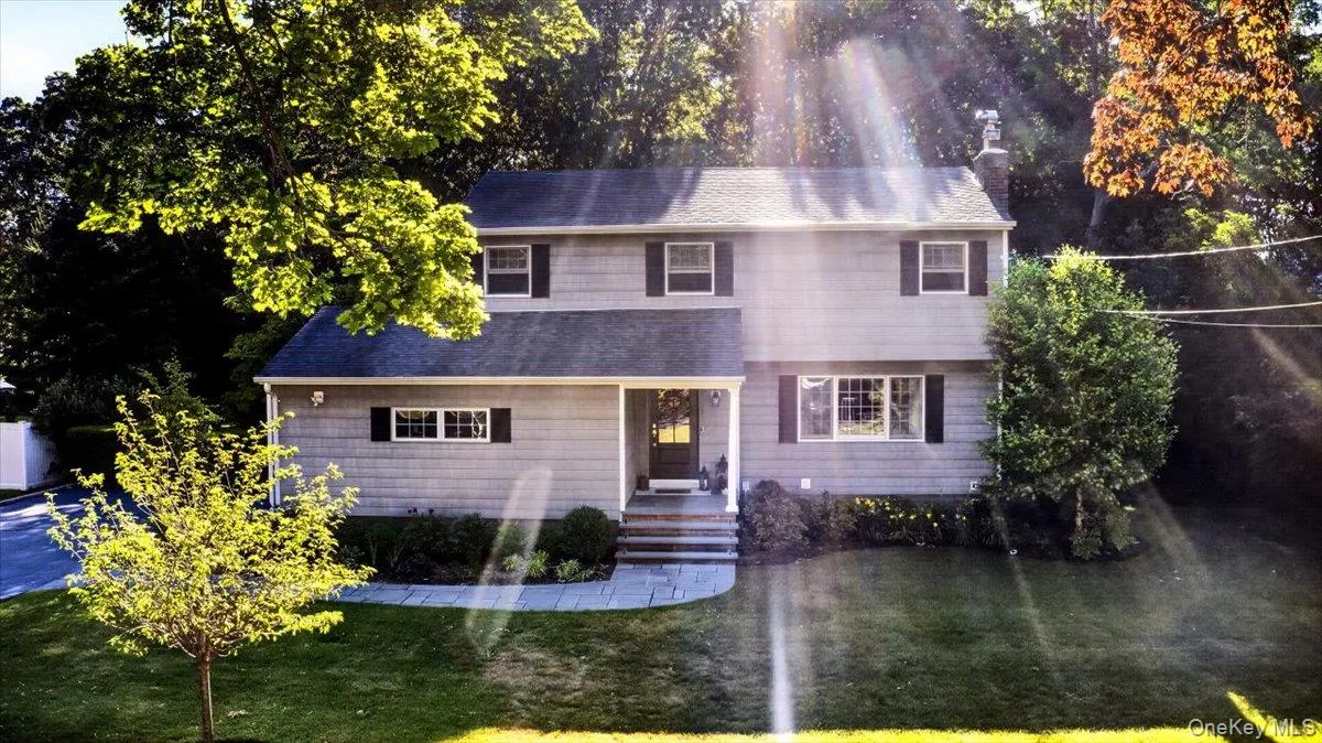 Two-story home featuring light grey siding with white trim and dark window shutters Two-story home featuring light grey siding with white trim and dark window shutters