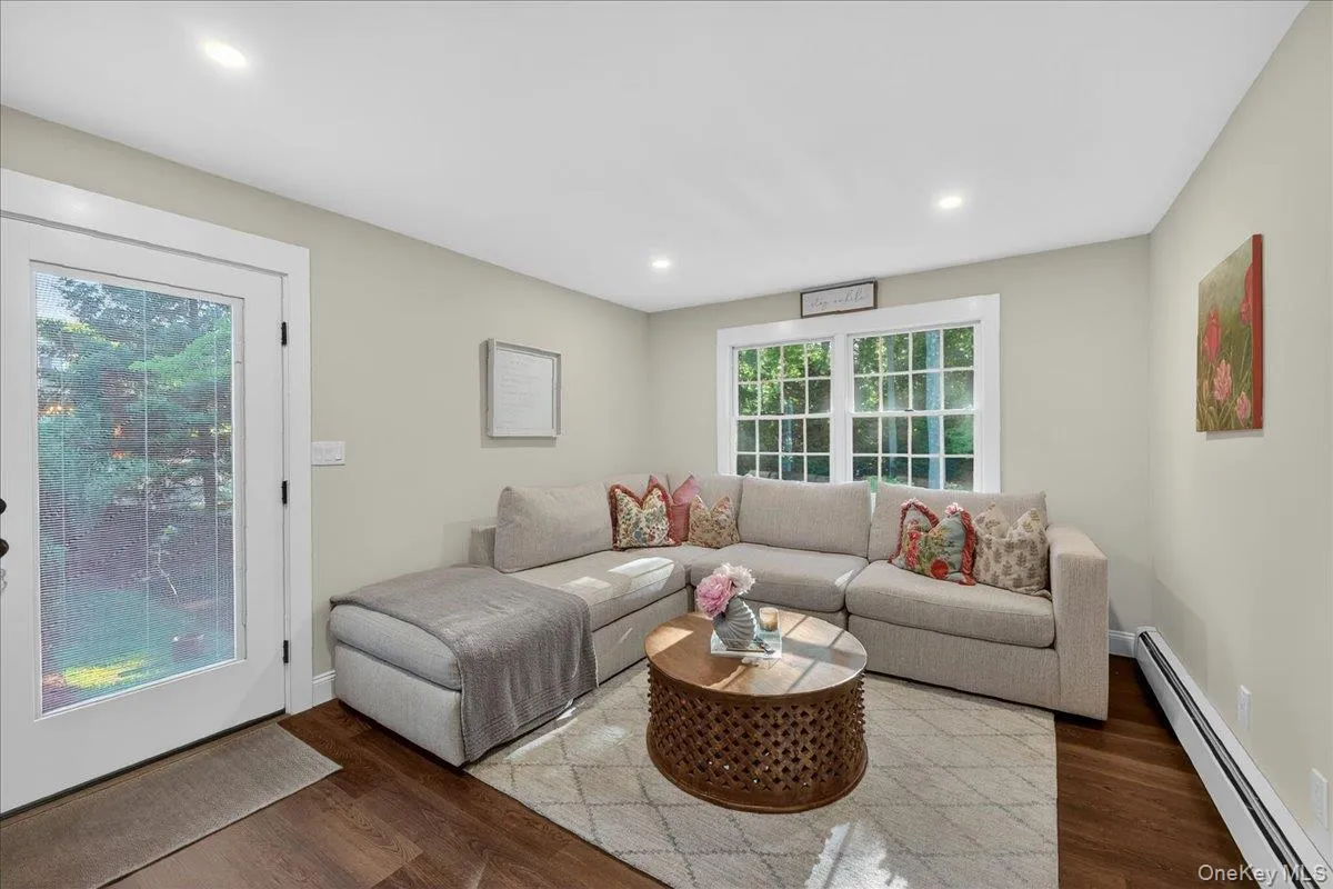 Bright living space featuring recessed lighting, hardwood-finish flooring, and a full-light exterior door Bright living space featuring recessed lighting, hardwood-finish flooring, and a full-light exterior door