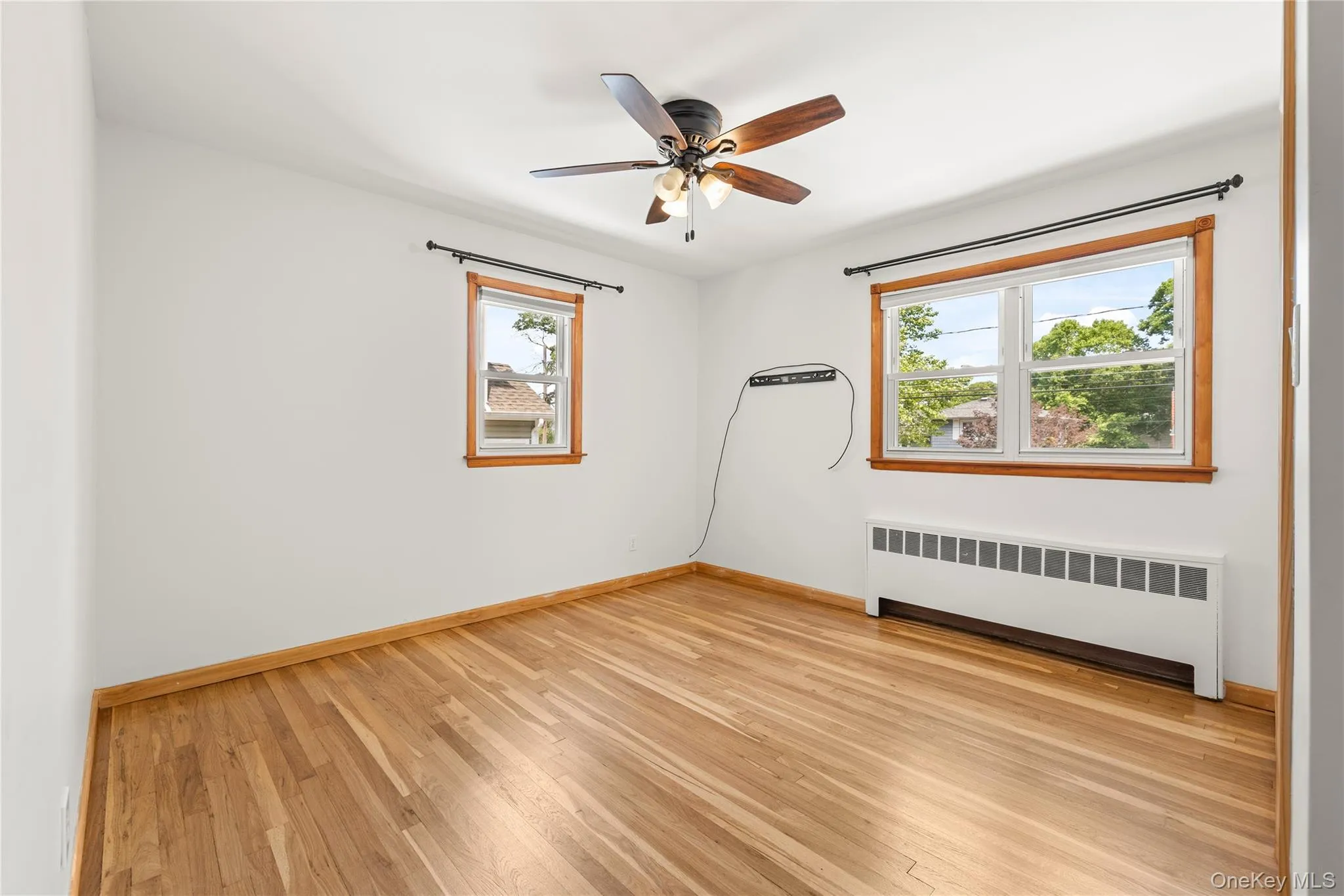 Primary with walk-in closet, Hardwood flooring throughout featuring natural wood trim, a ceiling fan with integrated lighting, Primary with walk-in closet, Hardwood flooring throughout featuring natural wood trim, a ceiling fan with integrated lighting,