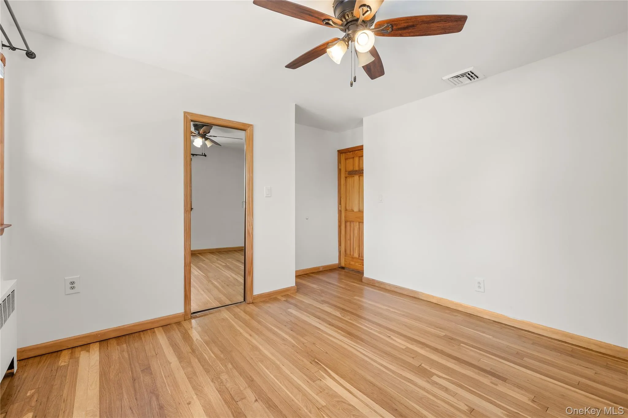 Primary with walk-in closet, Hardwood flooring throughout featuring natural wood trim, a ceiling fan with integrated lighting, Primary with walk-in closet, Hardwood flooring throughout featuring natural wood trim, a ceiling fan with integrated lighting,