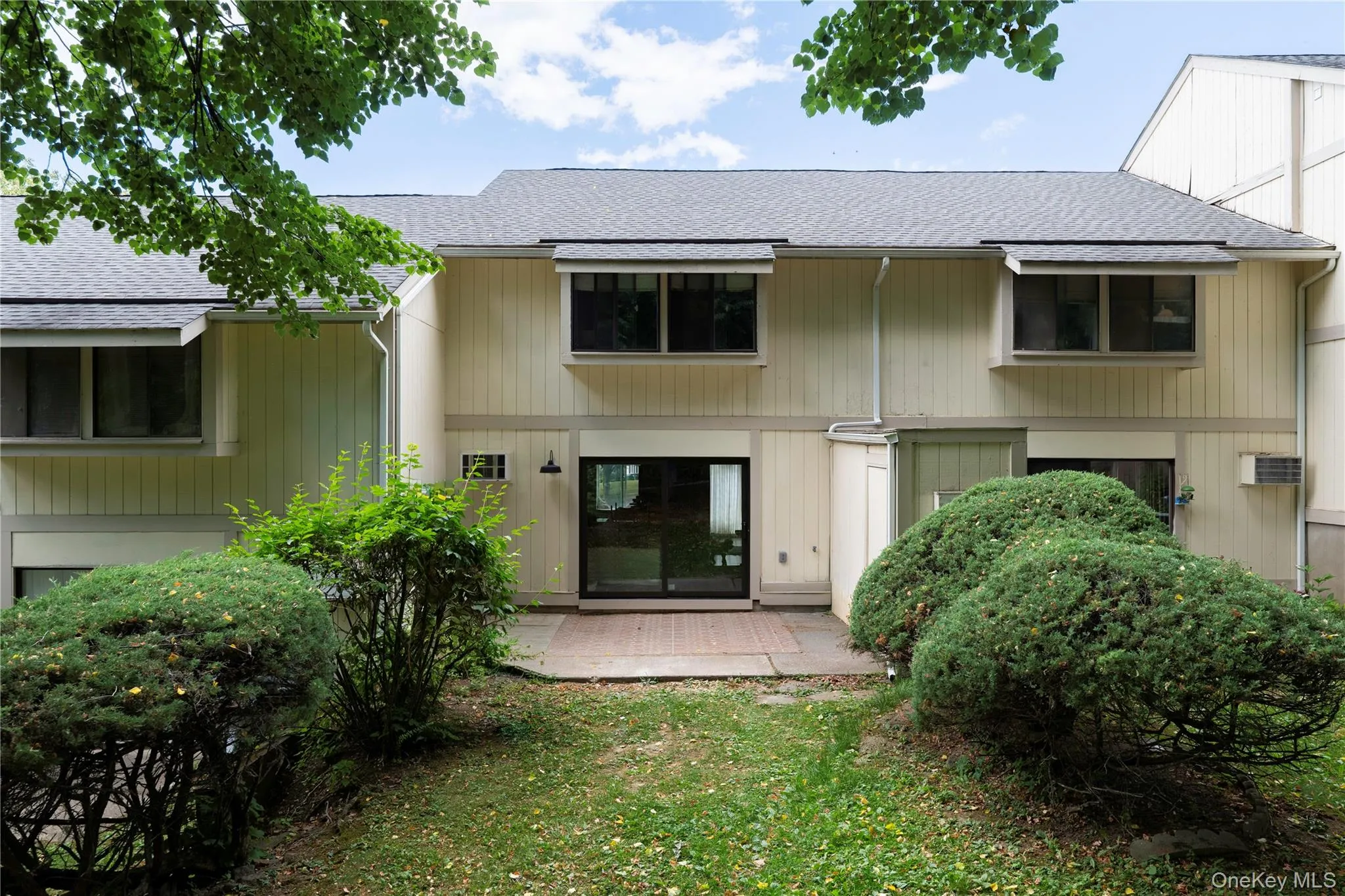 Exterior siding in a light neutral tone featuring a private patio space Exterior siding in a light neutral tone featuring a private patio space