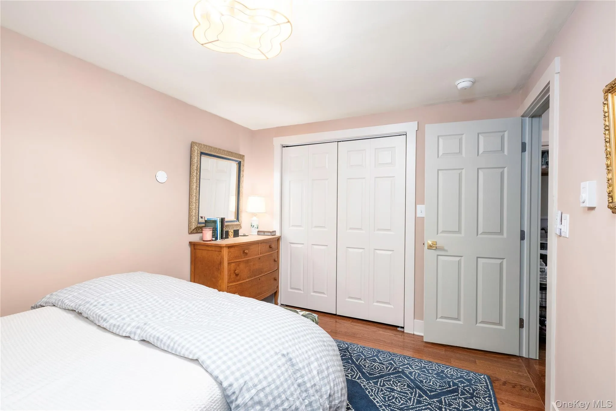 Bedroom featuring wood flooring, light colored walls, and a contemporary 'Fandelier' ceiling fixture Bedroom featuring wood flooring, light colored walls, and a contemporary 'Fandelier' ceiling fixture