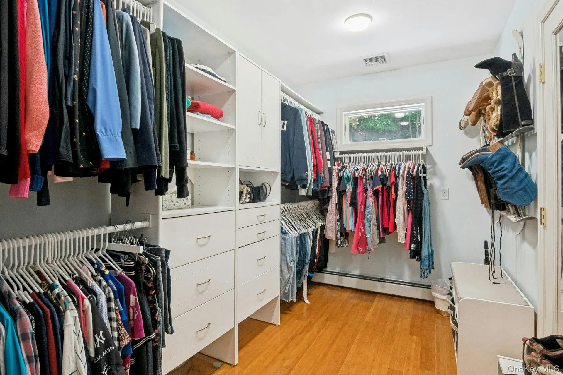 Large walk-in closet in primary suite with built in shelving, drawers and boot/shoe racks. Large walk-in closet in primary suite with built in shelving, drawers and boot/shoe racks.