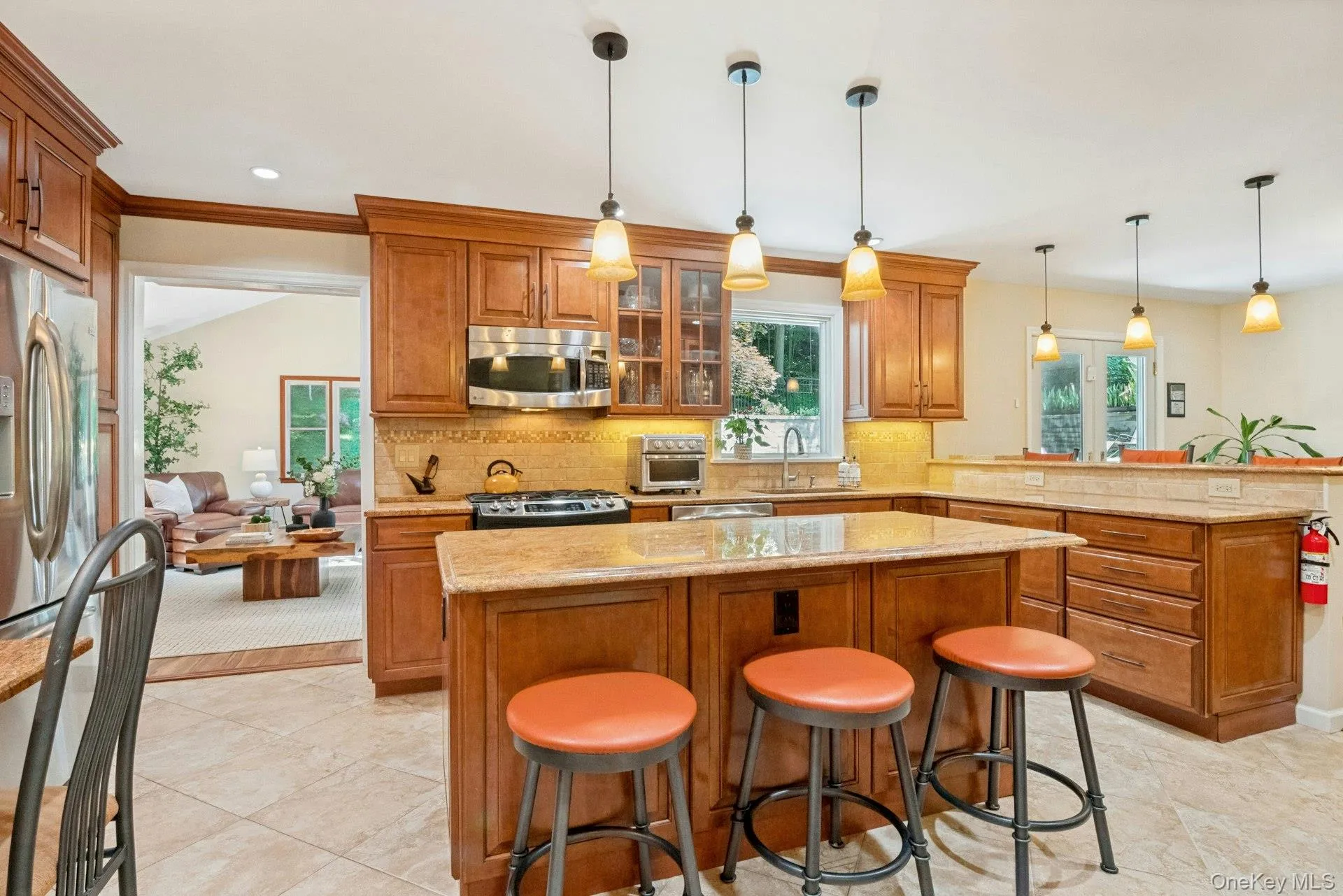 Front view of kitchen with island and bar stool seating. TV Room beyond through doorway. Front view of kitchen with island and bar stool seating. TV Room beyond through doorway.