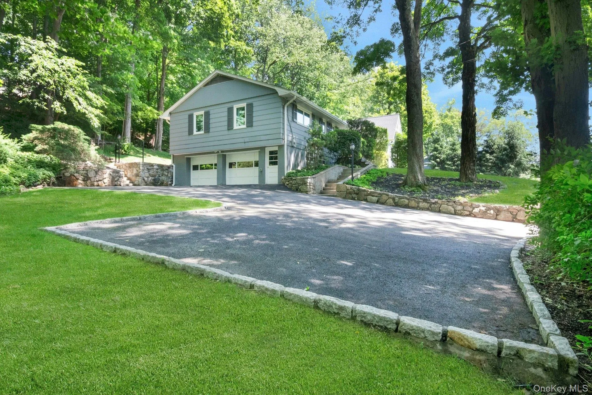 A view of side apron on driveway with house and 2 car garage visible. A view of side apron on driveway with house and 2 car garage visible.