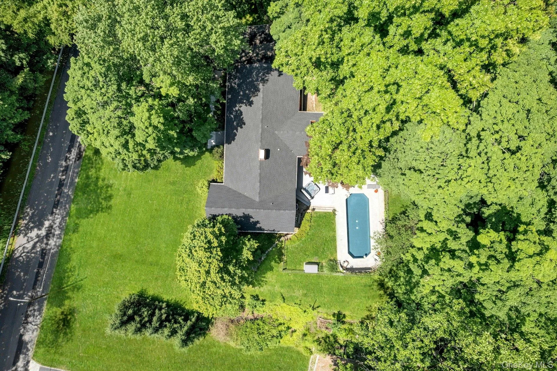 Aerial view of home with pool and mature trees/plantings surrounding property. Aerial view of home with pool and mature trees/plantings surrounding property.