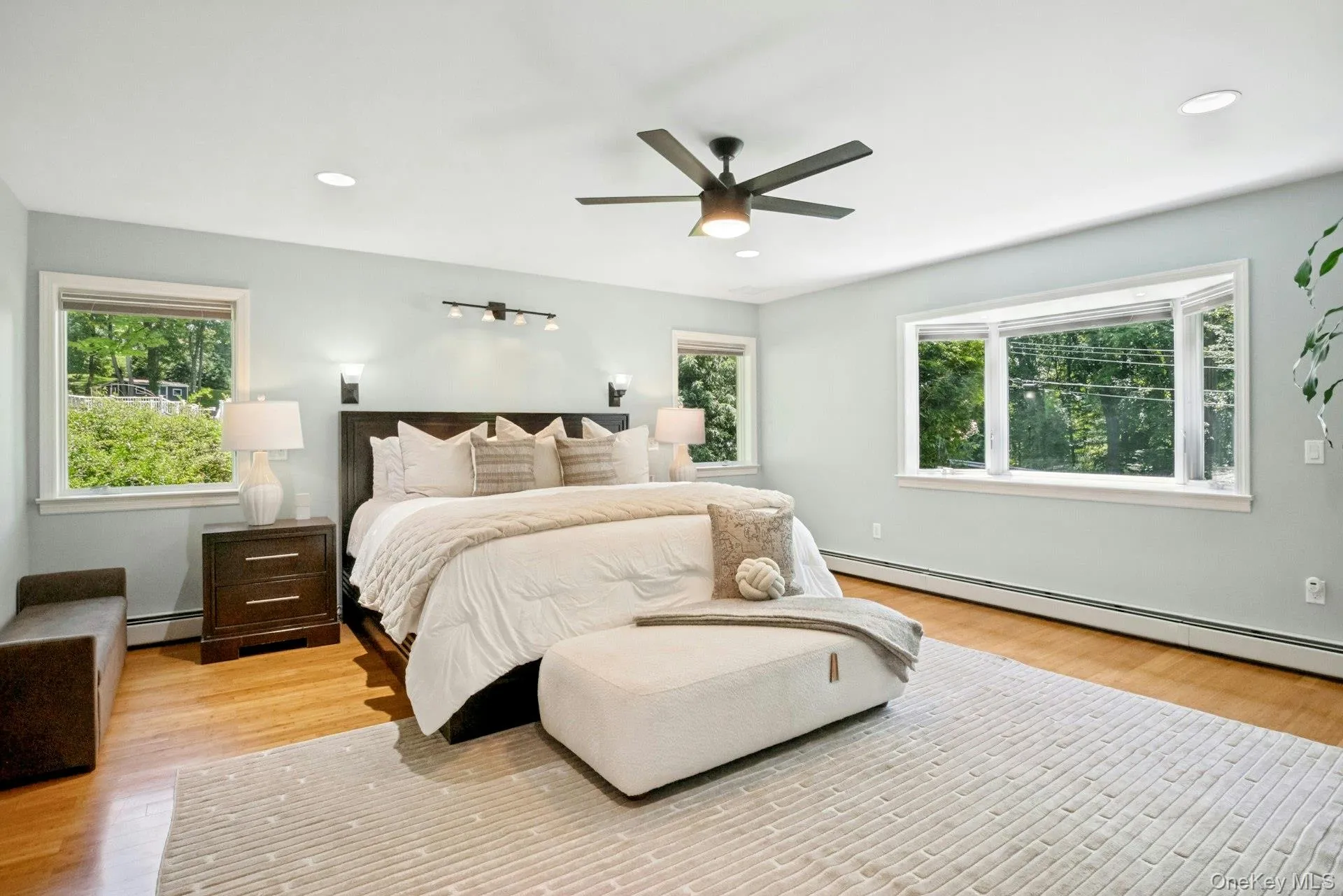 On the opposite side of the main level is the Primary suite with large bedroom, bamboo flooring and multiple windows. On the opposite side of the main level is the Primary suite with large bedroom, bamboo flooring and multiple windows.