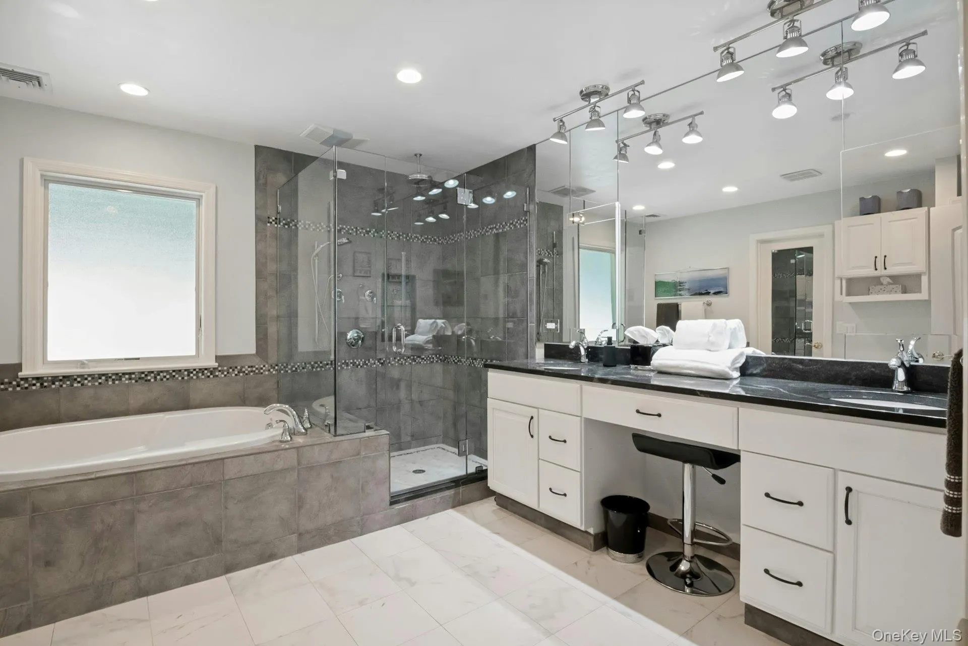 Luxurious primary bath with jacuzzi tub, shower, heated floors and double sink vanity. Luxurious primary bath with jacuzzi tub, shower, heated floors and double sink vanity.