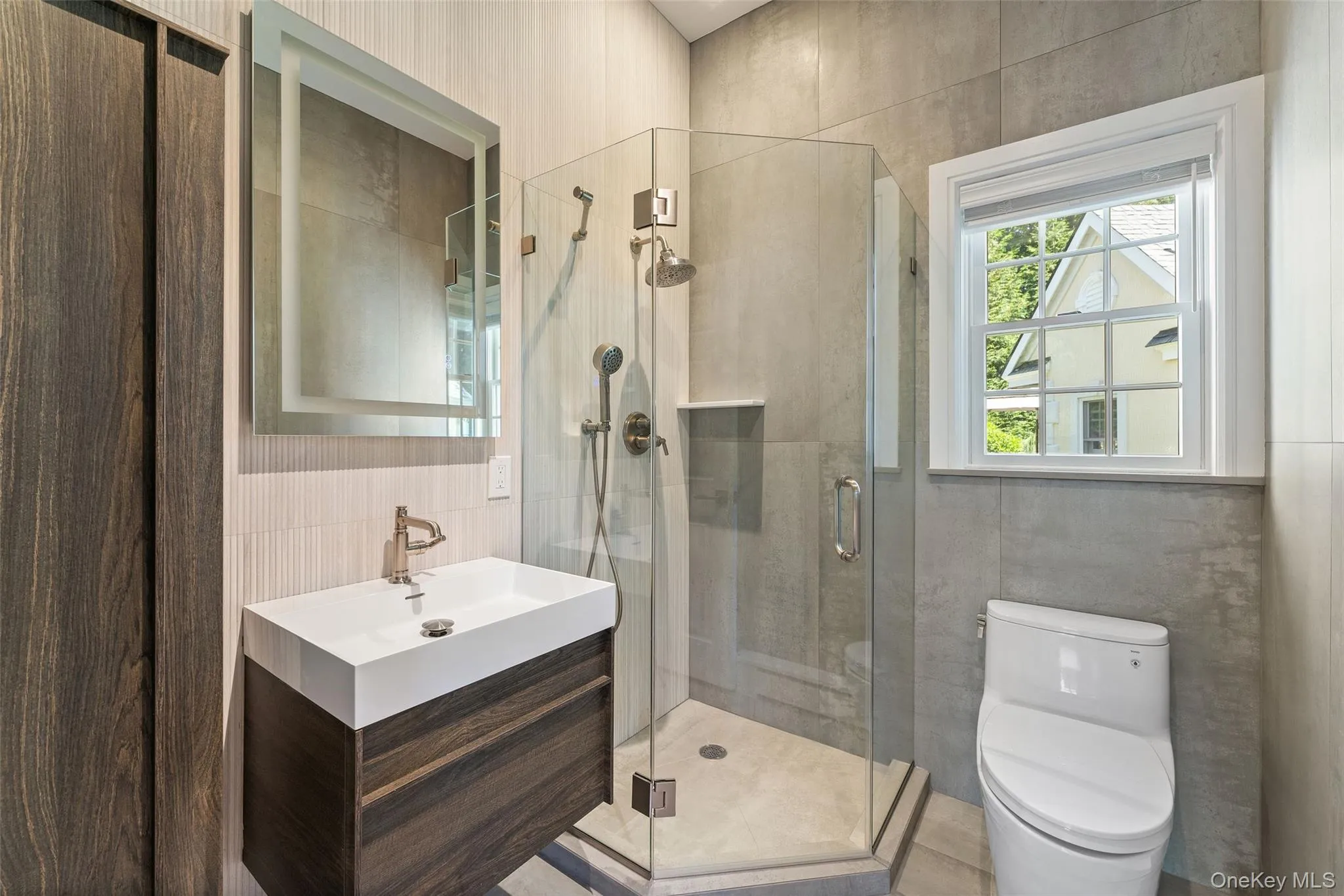 Full bath featuring tile walls, vanity, and a shower stall Full bath featuring tile walls, vanity, and a shower stall