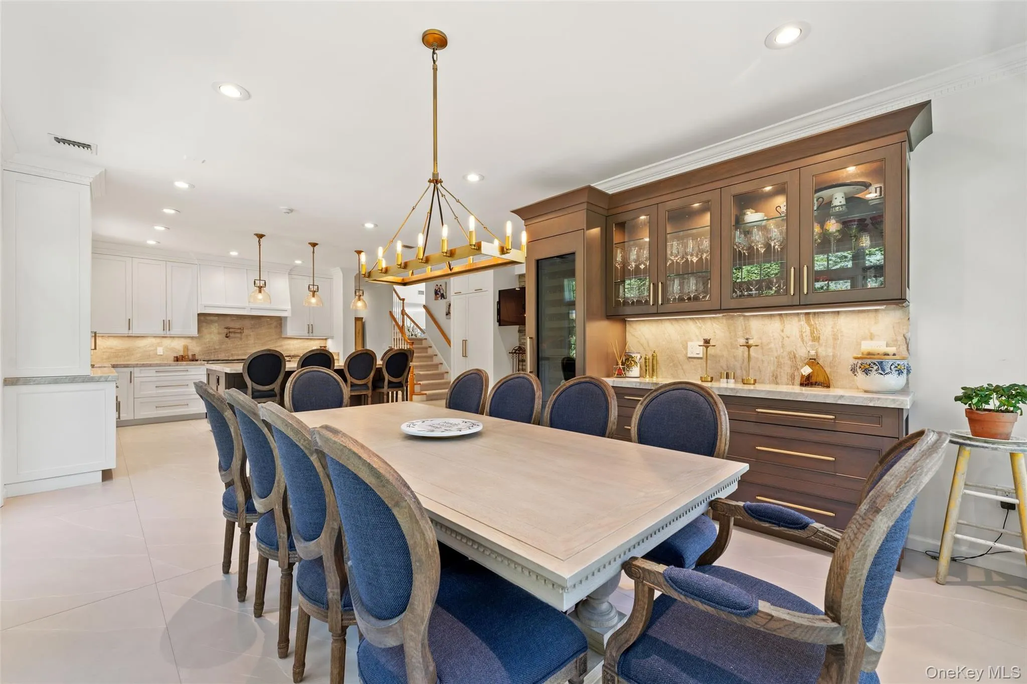 Dining room featuring recessed lighting, a chandelier, light tile patterned flooring, stairs, and ornamental molding Dining room featuring recessed lighting, a chandelier, light tile patterned flooring, stairs, and ornamental molding