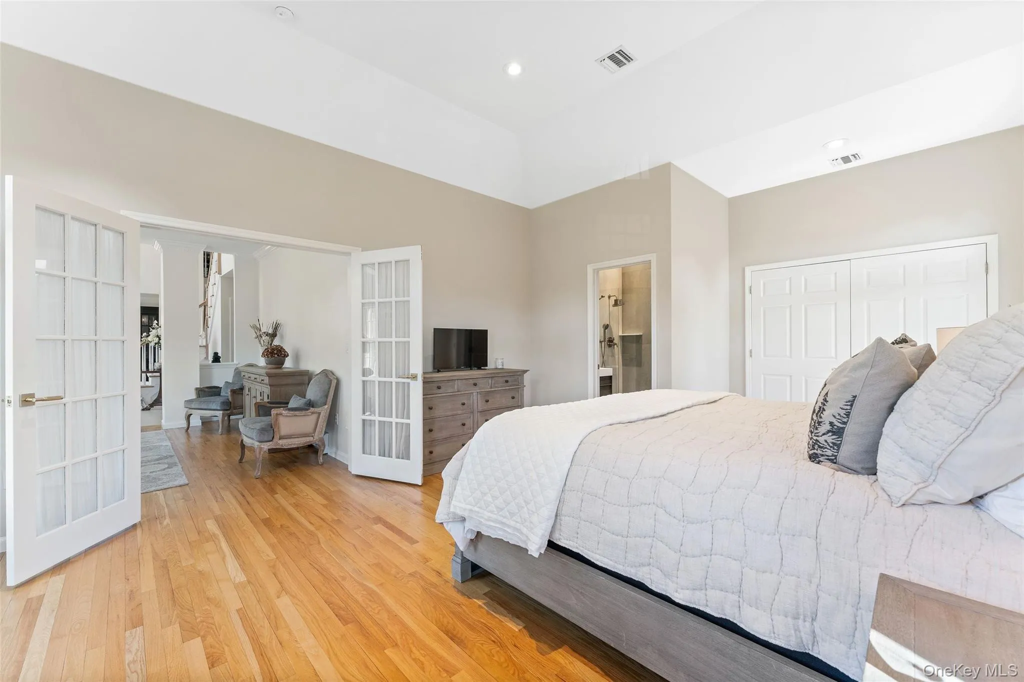Bedroom featuring light wood-style flooring and french doors Bedroom featuring light wood-style flooring and french doors